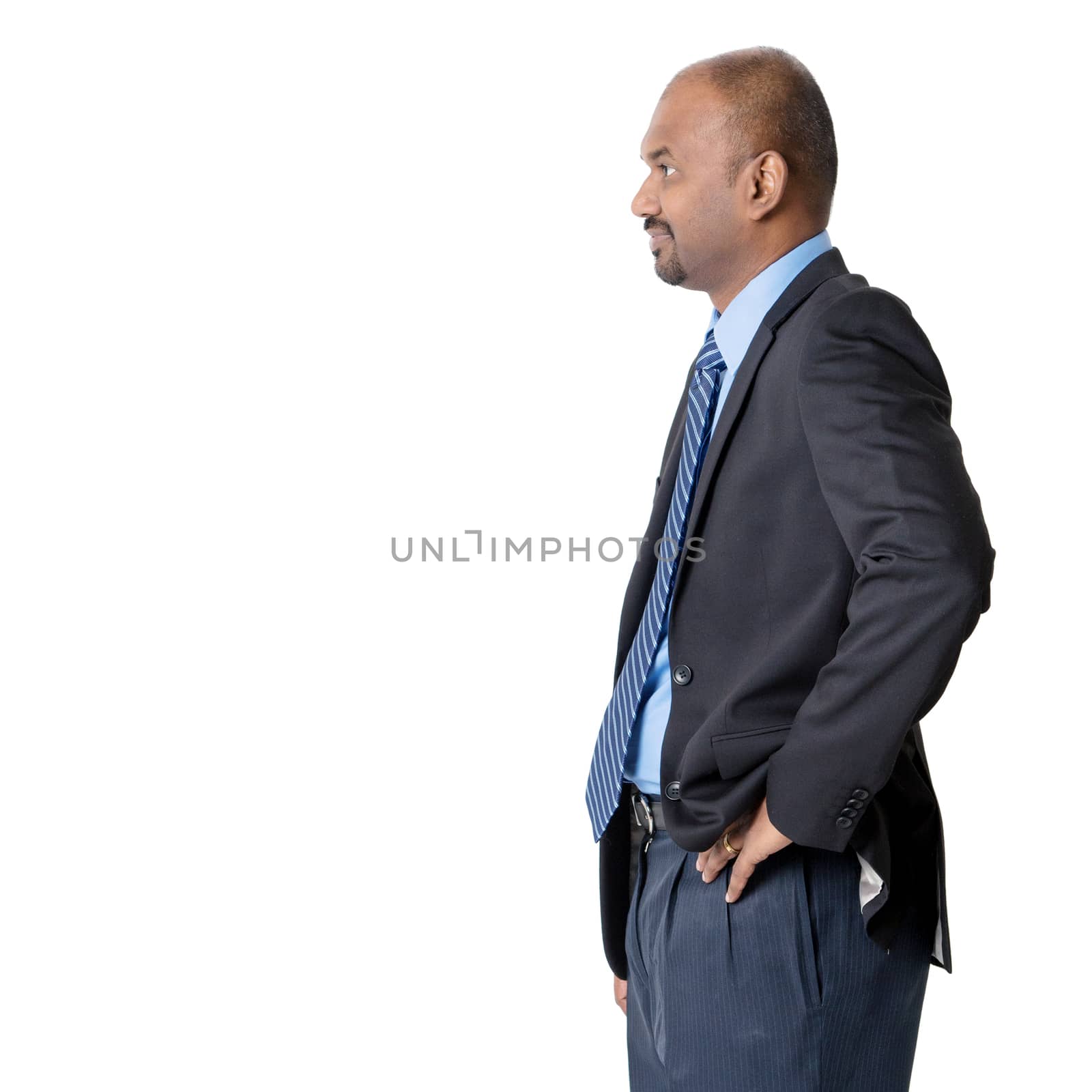 Side view of Indian businessman standing and looking forward, isolated on white background