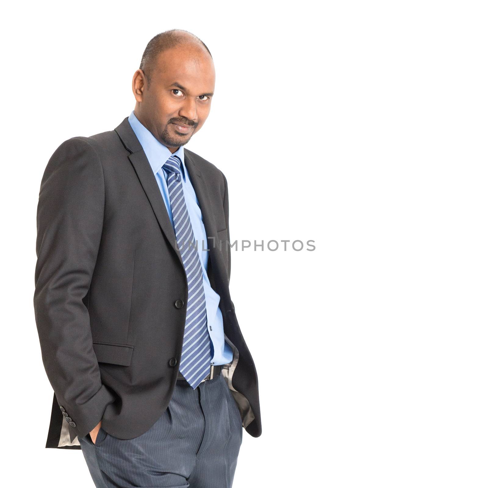 Indian businessman in formal suit looking at camera, isolated on white background.