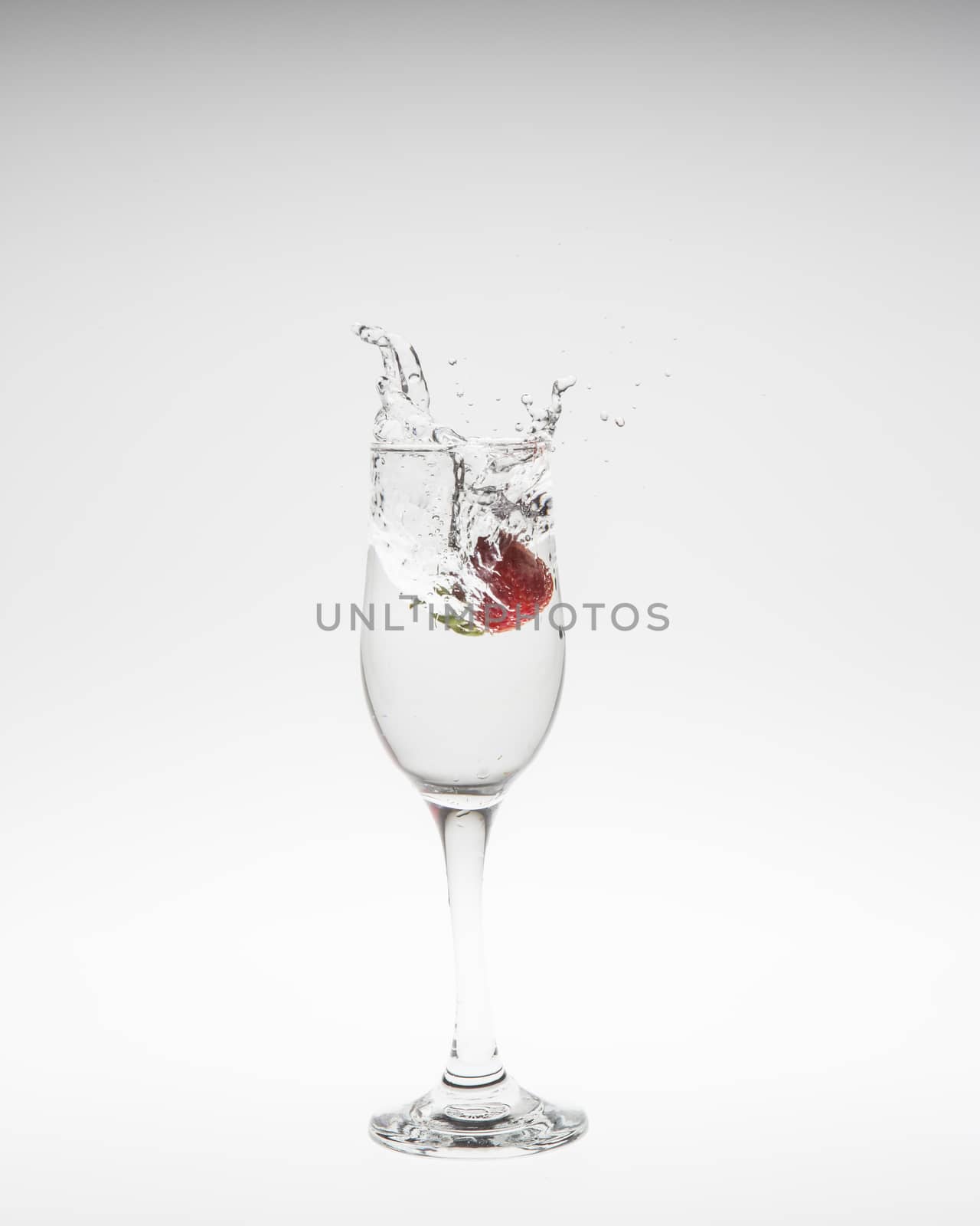 fresh strawberry dropped into water with splash on white backgro by Chattranusorn09