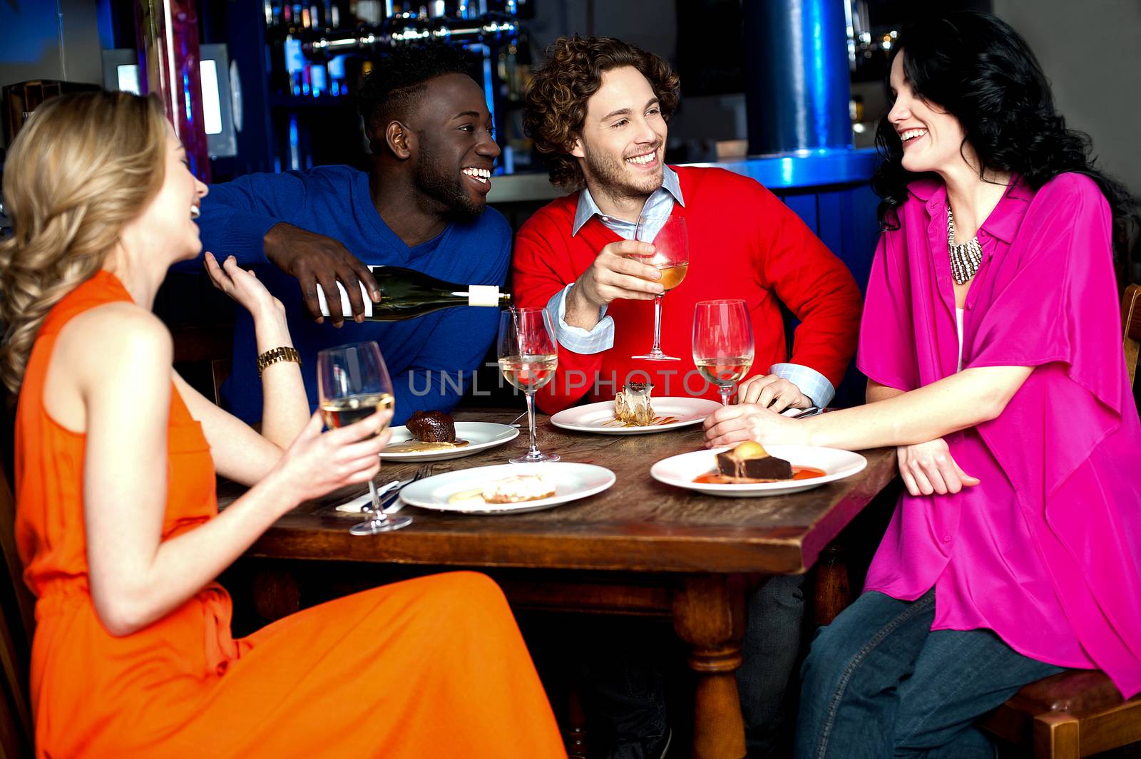 Four friends enjoying drinks at restaurant