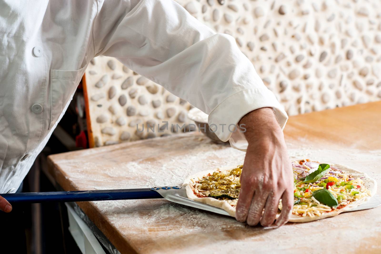 Chef taking pizza dough to cook by stockyimages