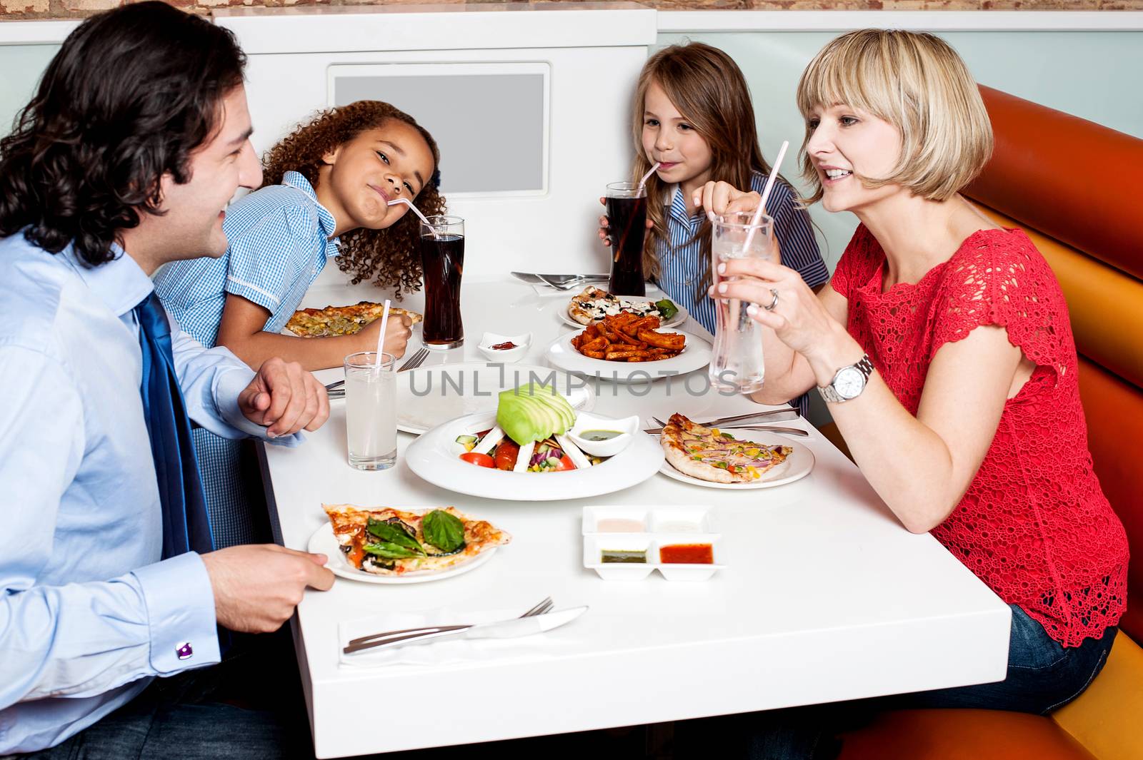 Happy family of four together in a restaurant