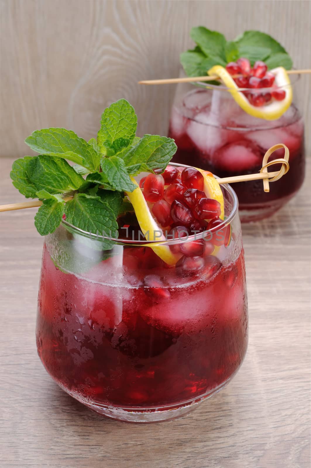 Pomegranate cocktail with slices of lime, mint and ice