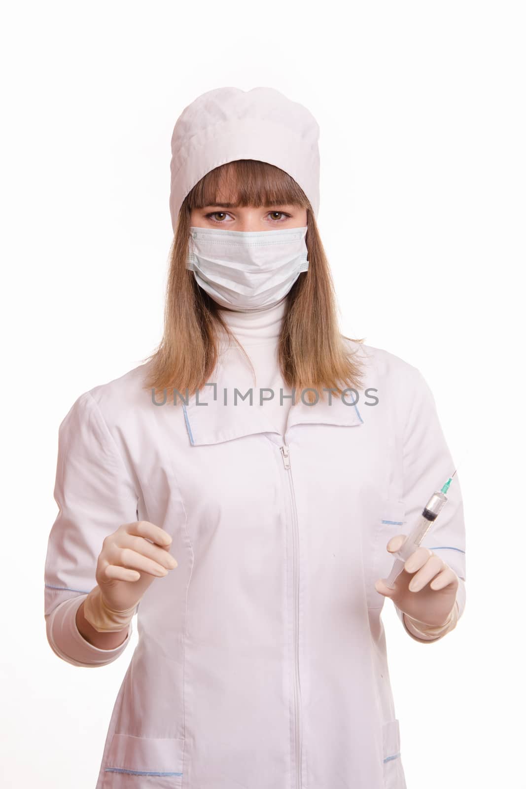 Portrait of medical worker in a white coat, hat, gloves and a mask, with a syringe and vial in hands