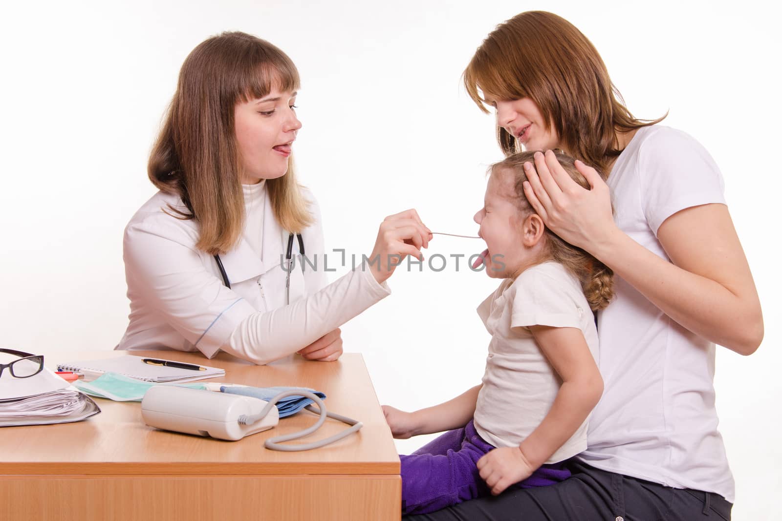 Doctor pediatrician examines a sick child at home