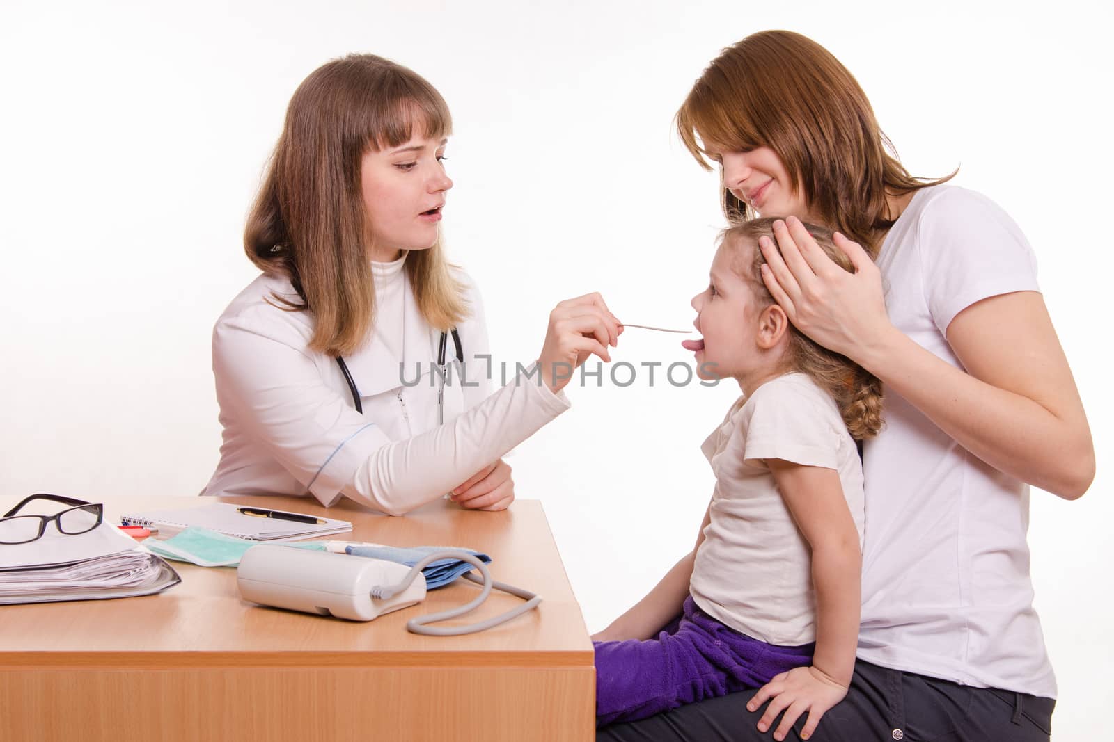 Doctor pediatrician examines a sick child at home
