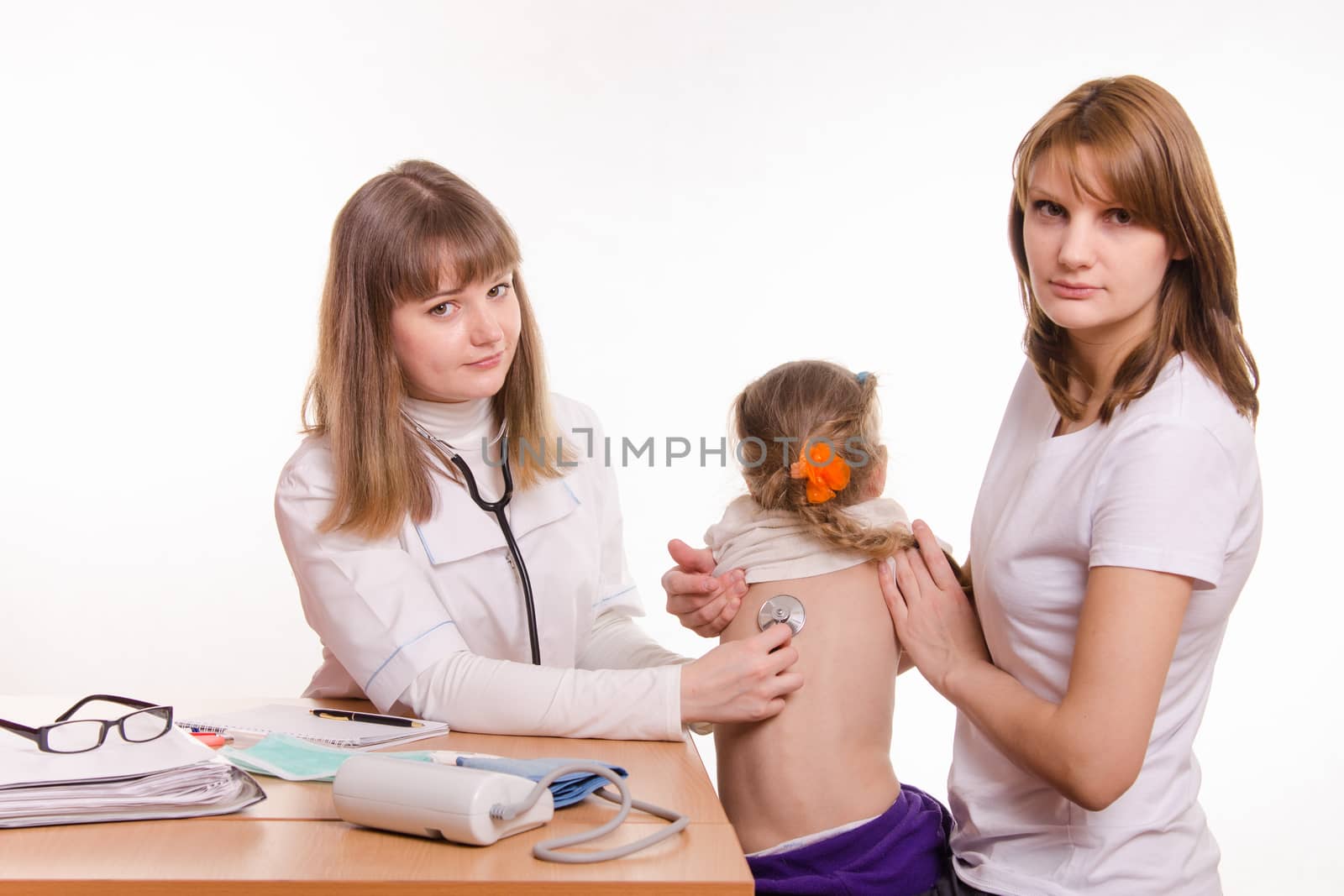 Doctor pediatrician examines a sick child at home