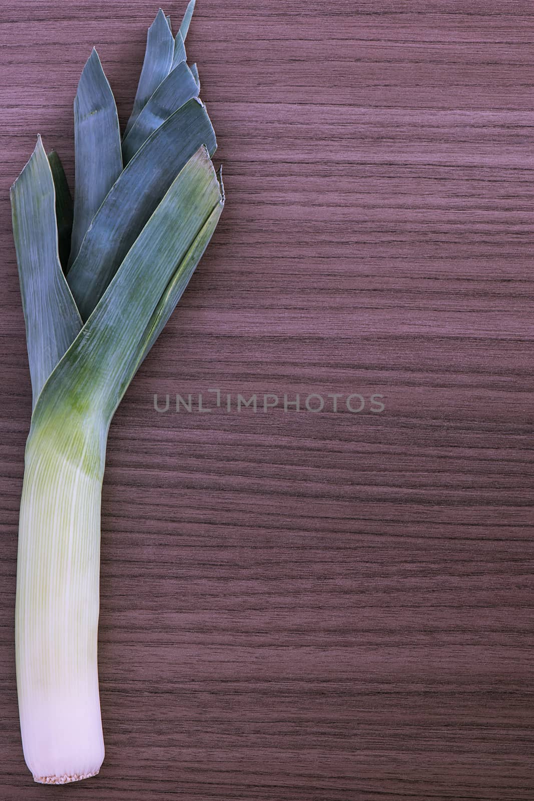 A fresh leek over wood background (vertical)