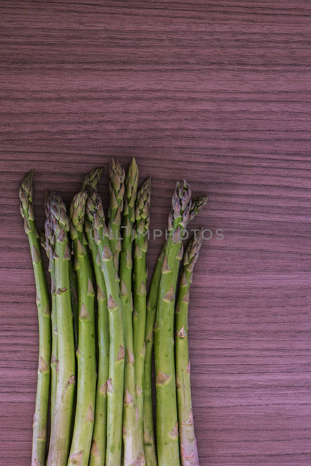 Some green fresh asparagus over wood background 