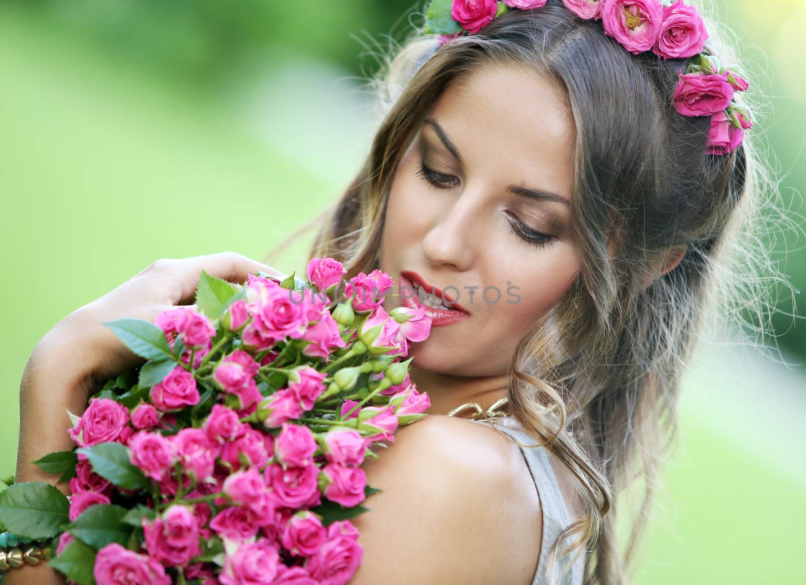 Portrait of a beautiful girl holding bouquet of flowers in the park