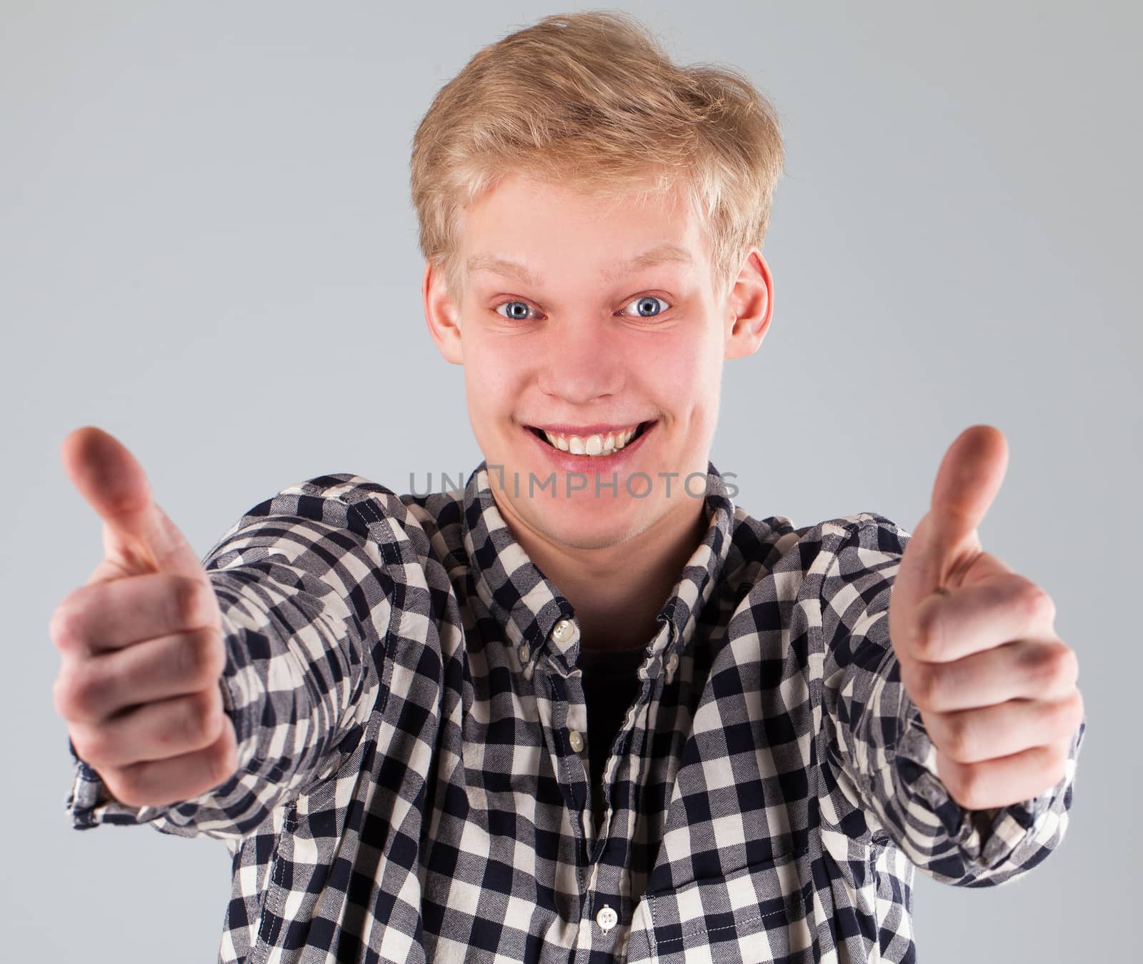 Portrait of young handsome guy over grey background