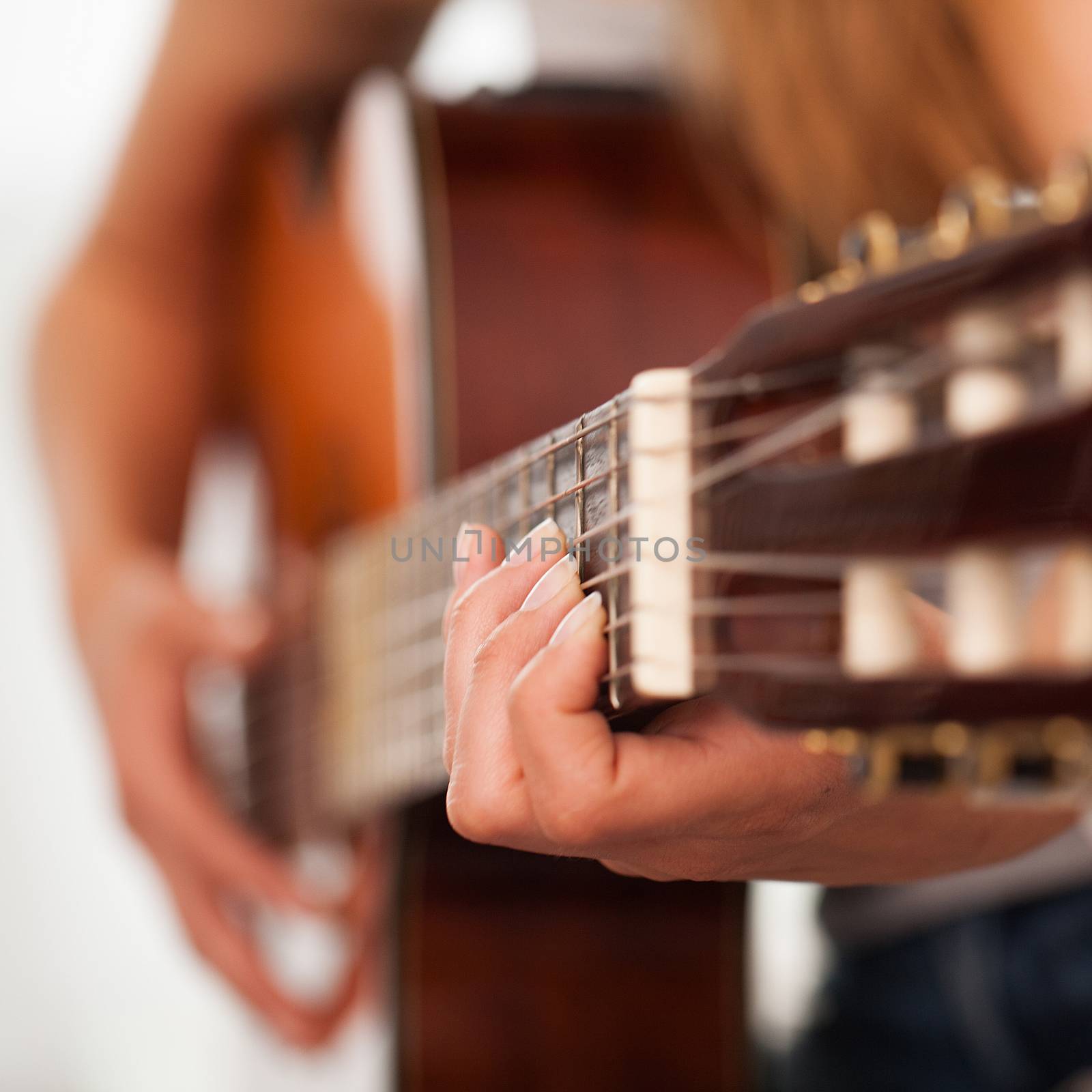 Closeup image of guitar in caucasian woman hands