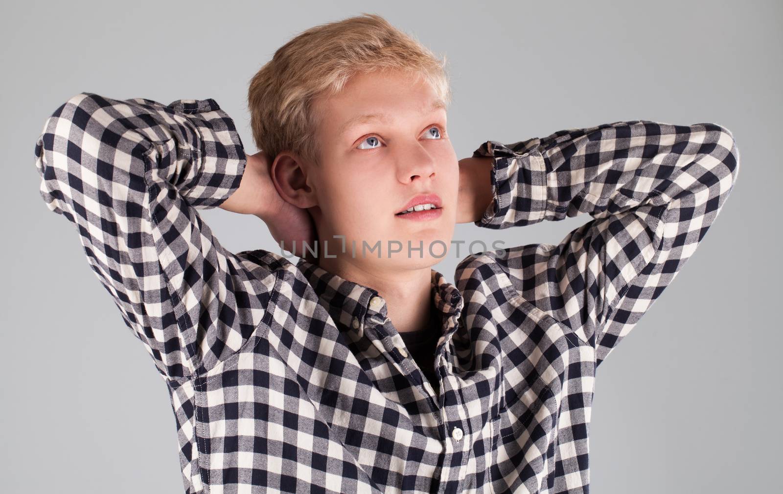 Portrait of young handsome guy over grey background