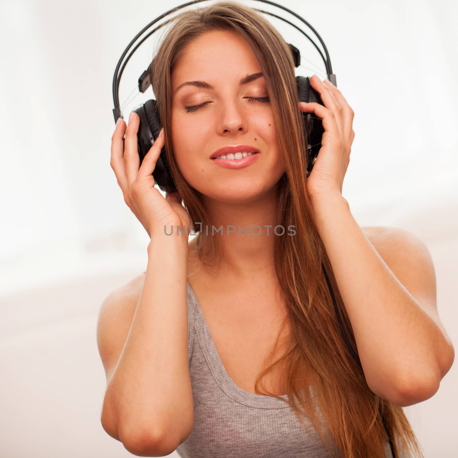Beautiful woman enjoy music in headphones sitting on a floor