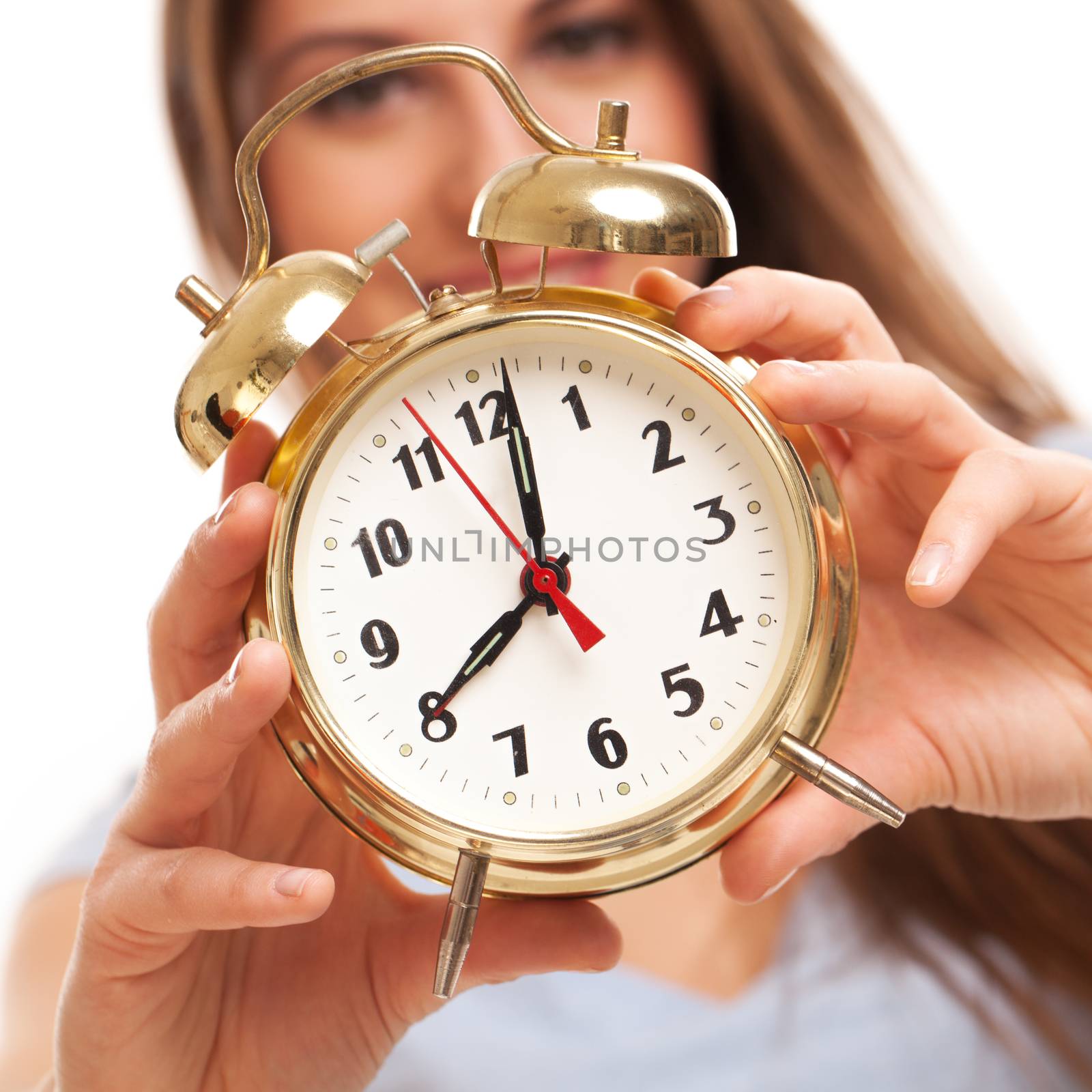 Young caucasian woman with alarm clock in her hands