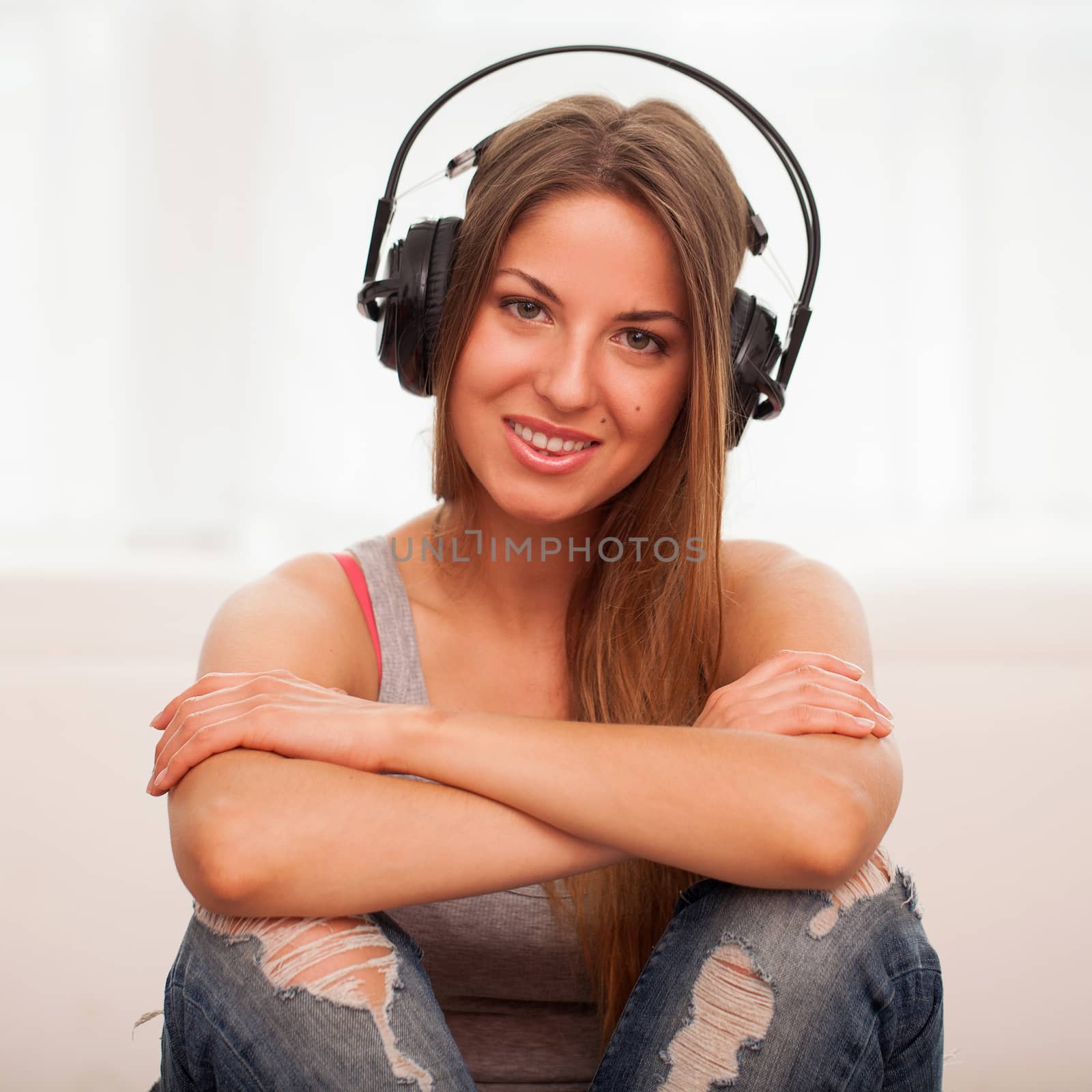 Beautiful woman enjoy music in headphones sitting on a floor