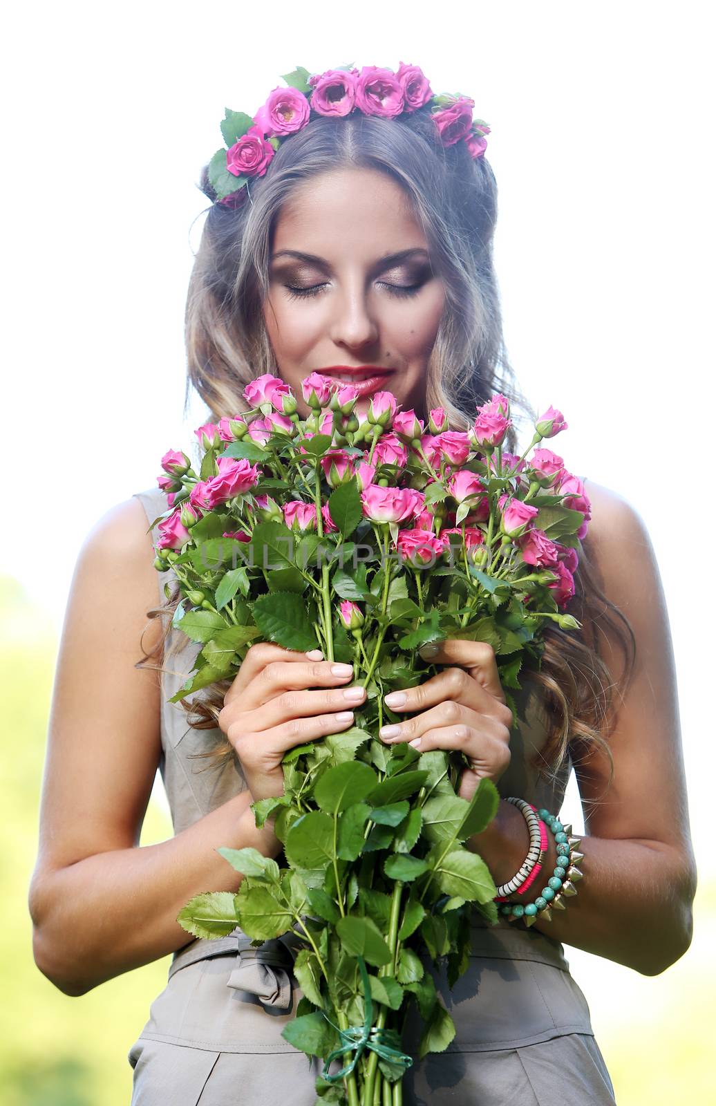 Portrait of a beautiful girl holding bouquet of flowers in the park