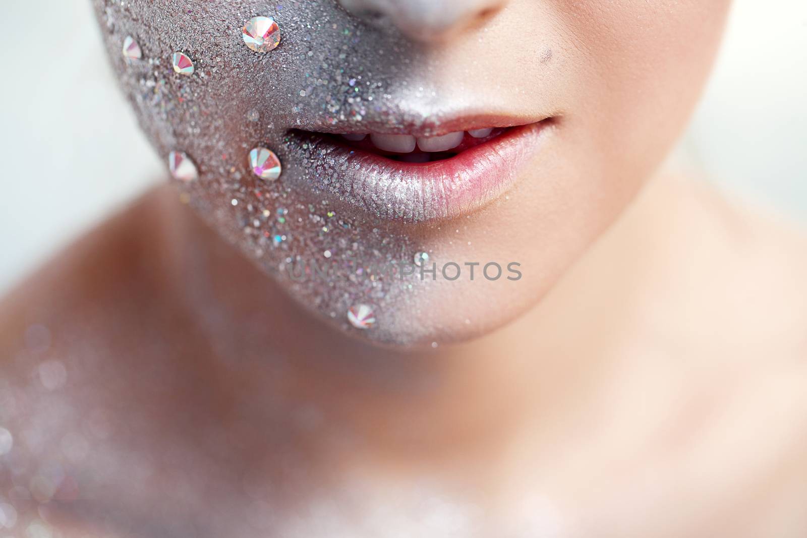 Portrait of a beautiful girl with silver body art over a white background