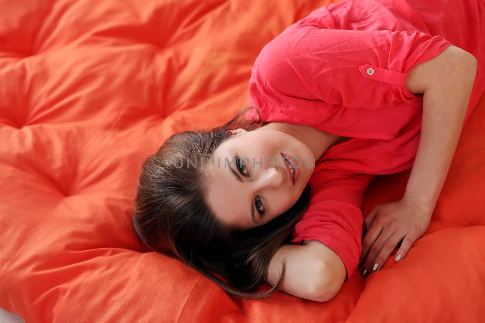 Sensual young woman dreaming on an orange blanket