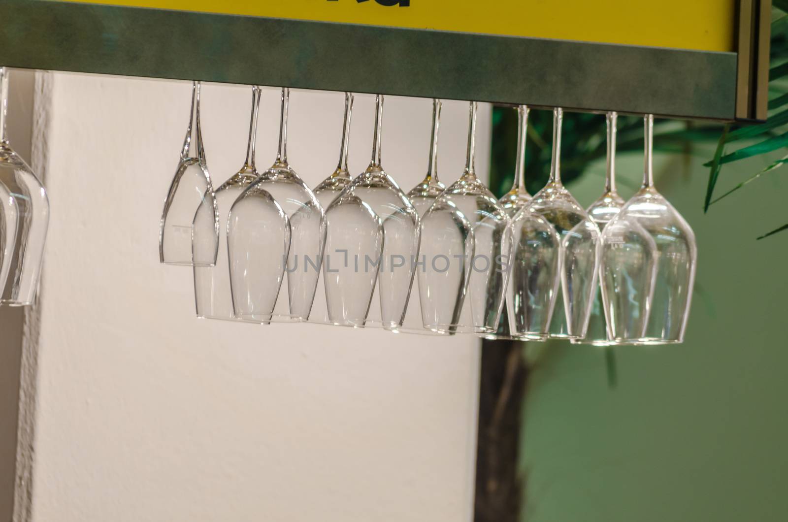 Glasses for drinks hanging in a bar.