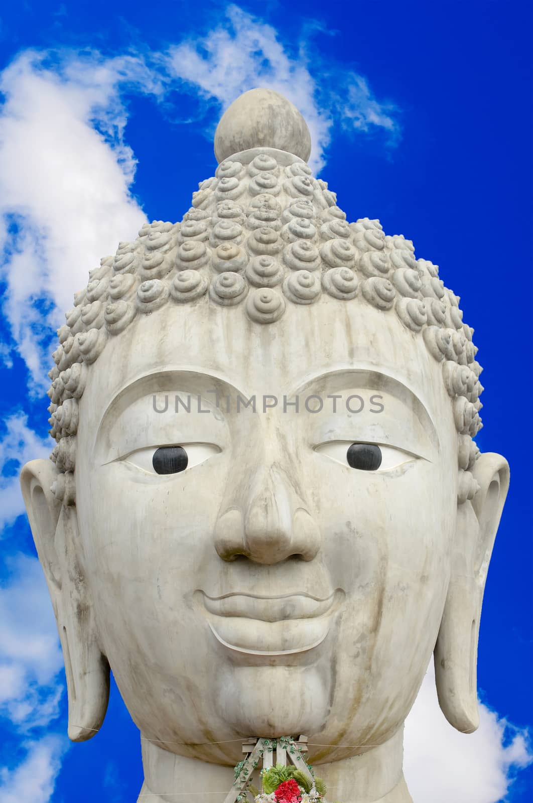 The Head of Buddha Image and Cloudy Blue Sky Background.