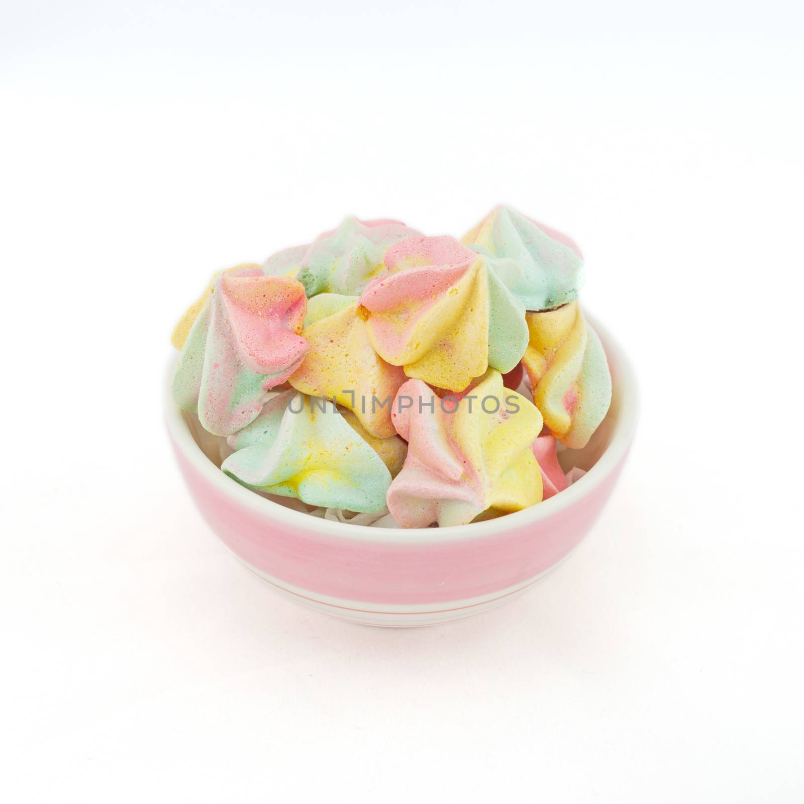 French rainbow meringue cookies on white background with copy space. Macro with shallow dof.