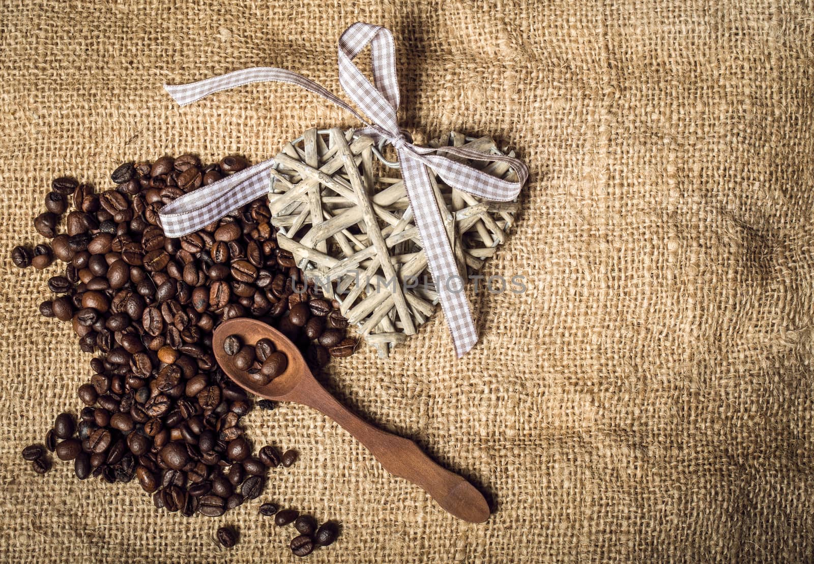 pile of fresh and bio aromatic coffee beans and wooden spoon with space for text