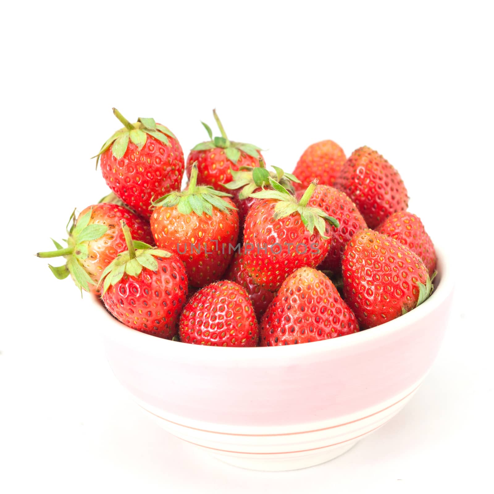 Small white bowl filled with succulent juicy fresh ripe red strawberries isolated on white