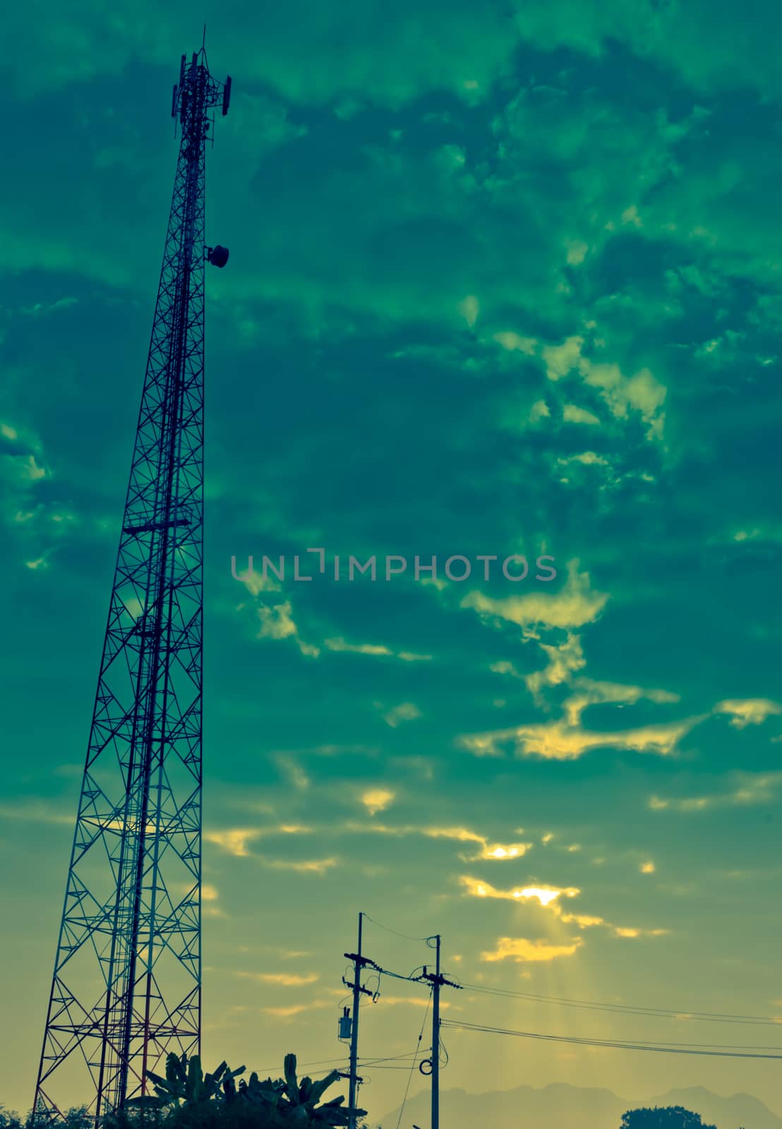 Communication Antenna Tower and Cloudy Sky with Sunbeam by kobfujar