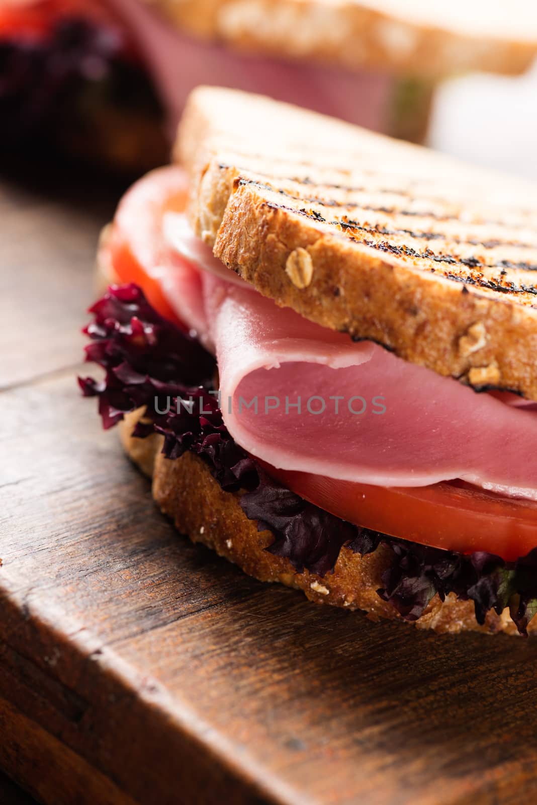 Sandwich with ham salad tomato on wood by Nanisimova