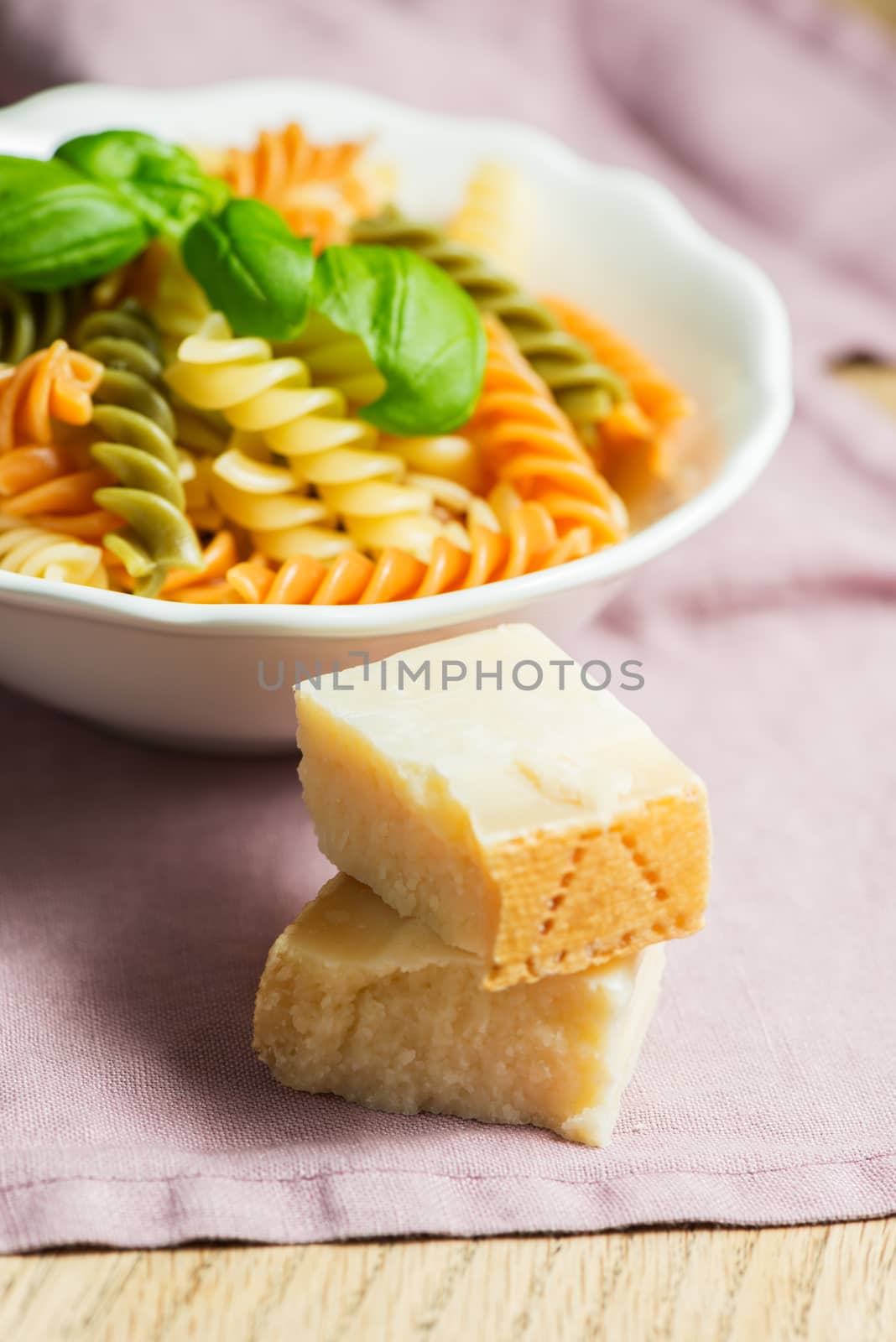 Italian pasta with basil and parmesan cheese, served on a white plate