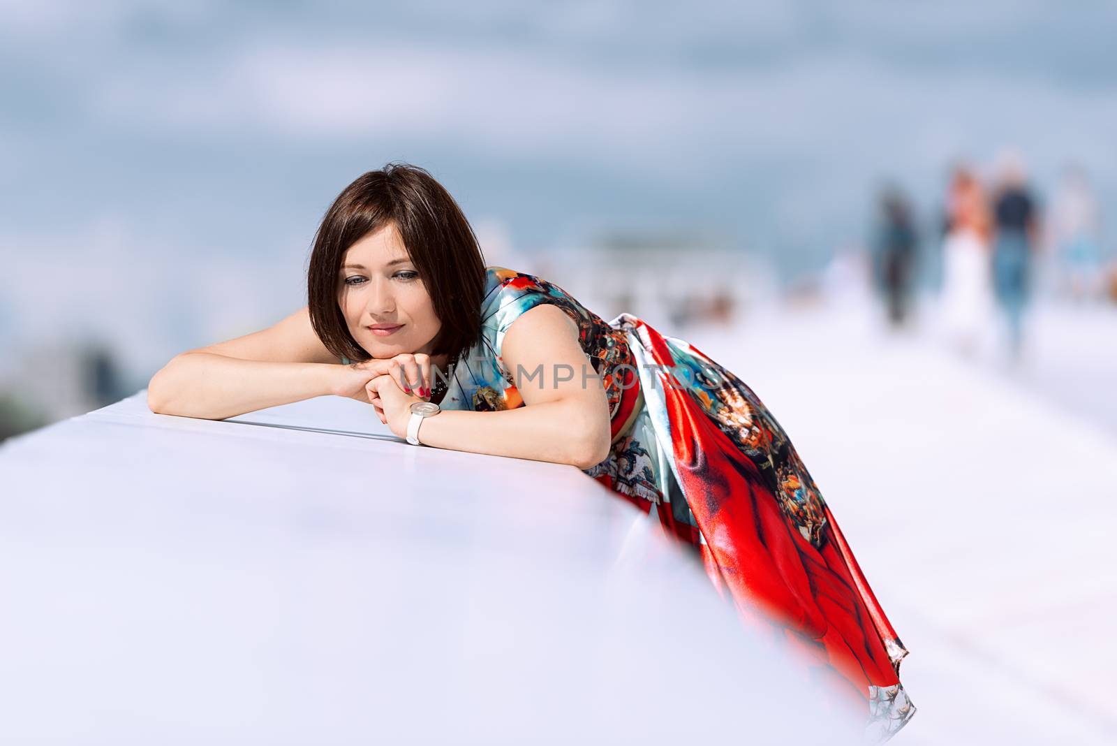 Brunette girl model in dress posing on exterior set