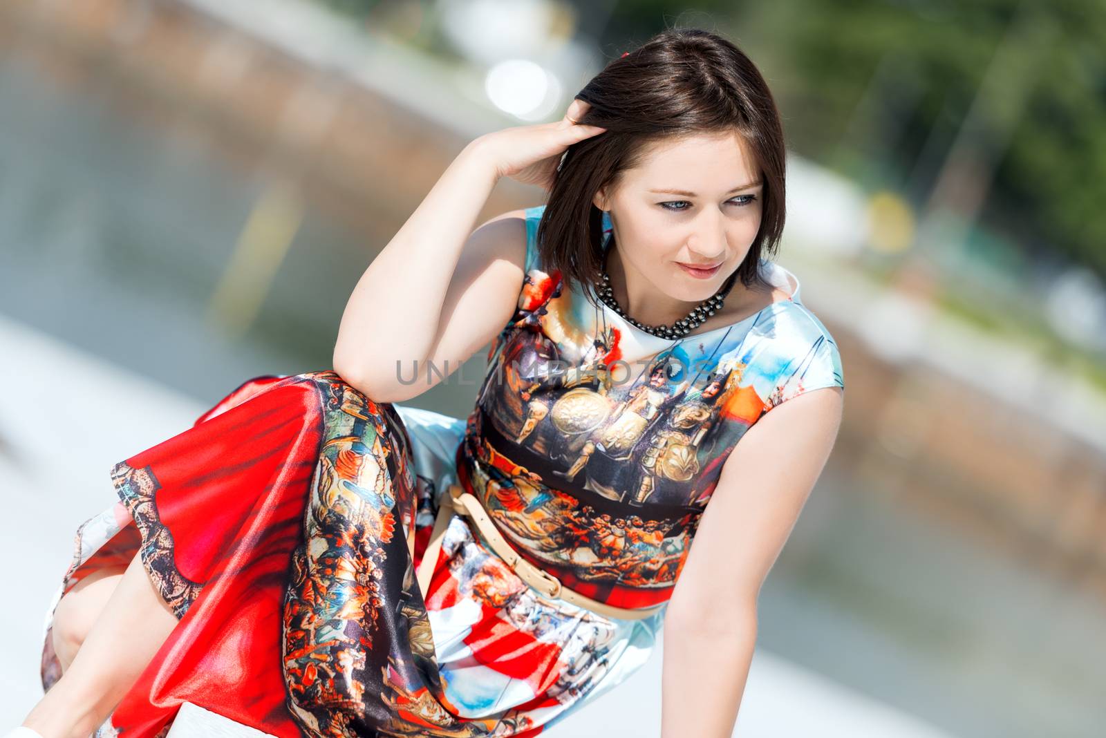 Model in dress posing on exterior set angled by Nanisimova