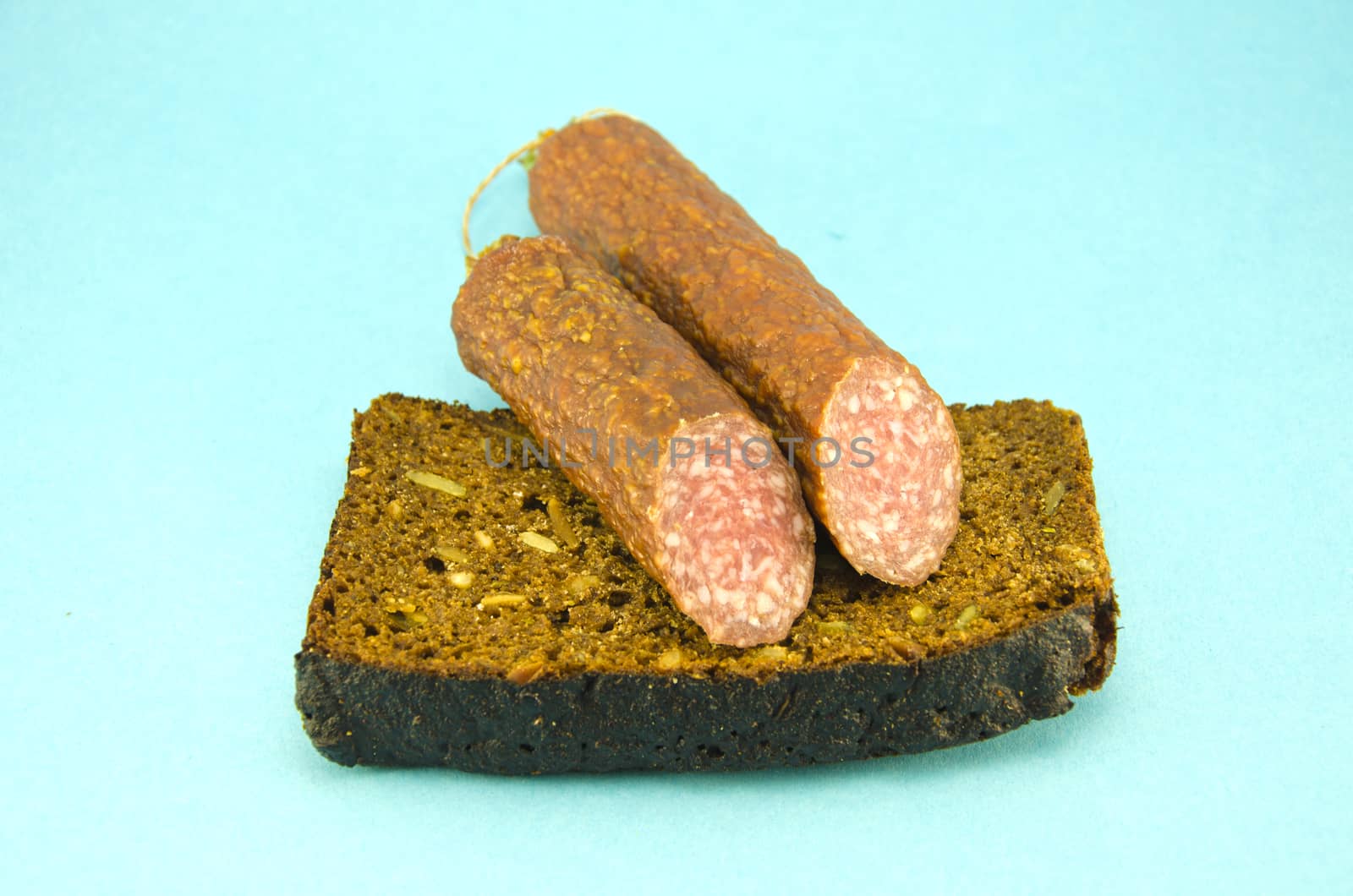 brown ecological bread and sausage on blue background