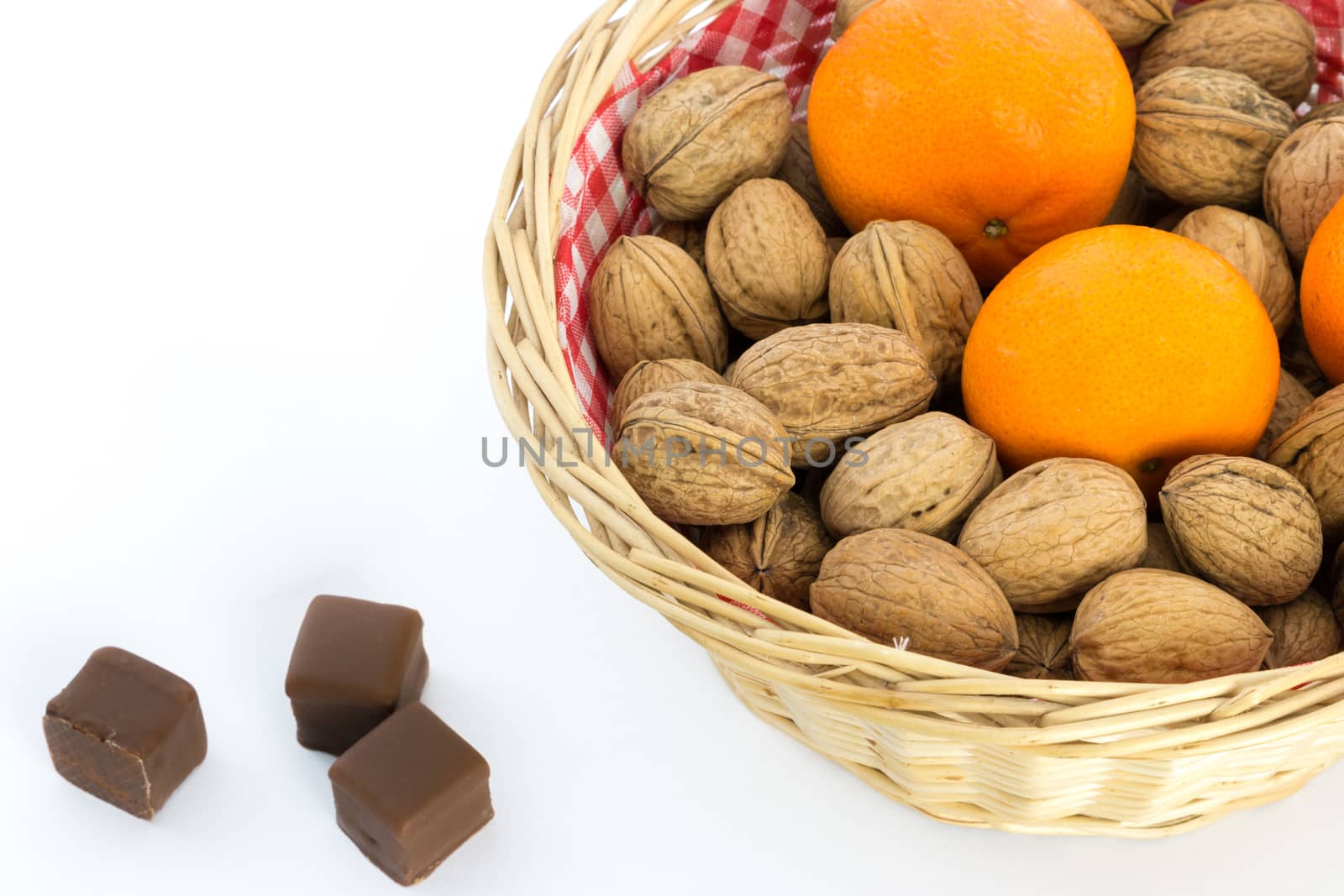 Small basket with walnuts and tangerines, chocolate on the side