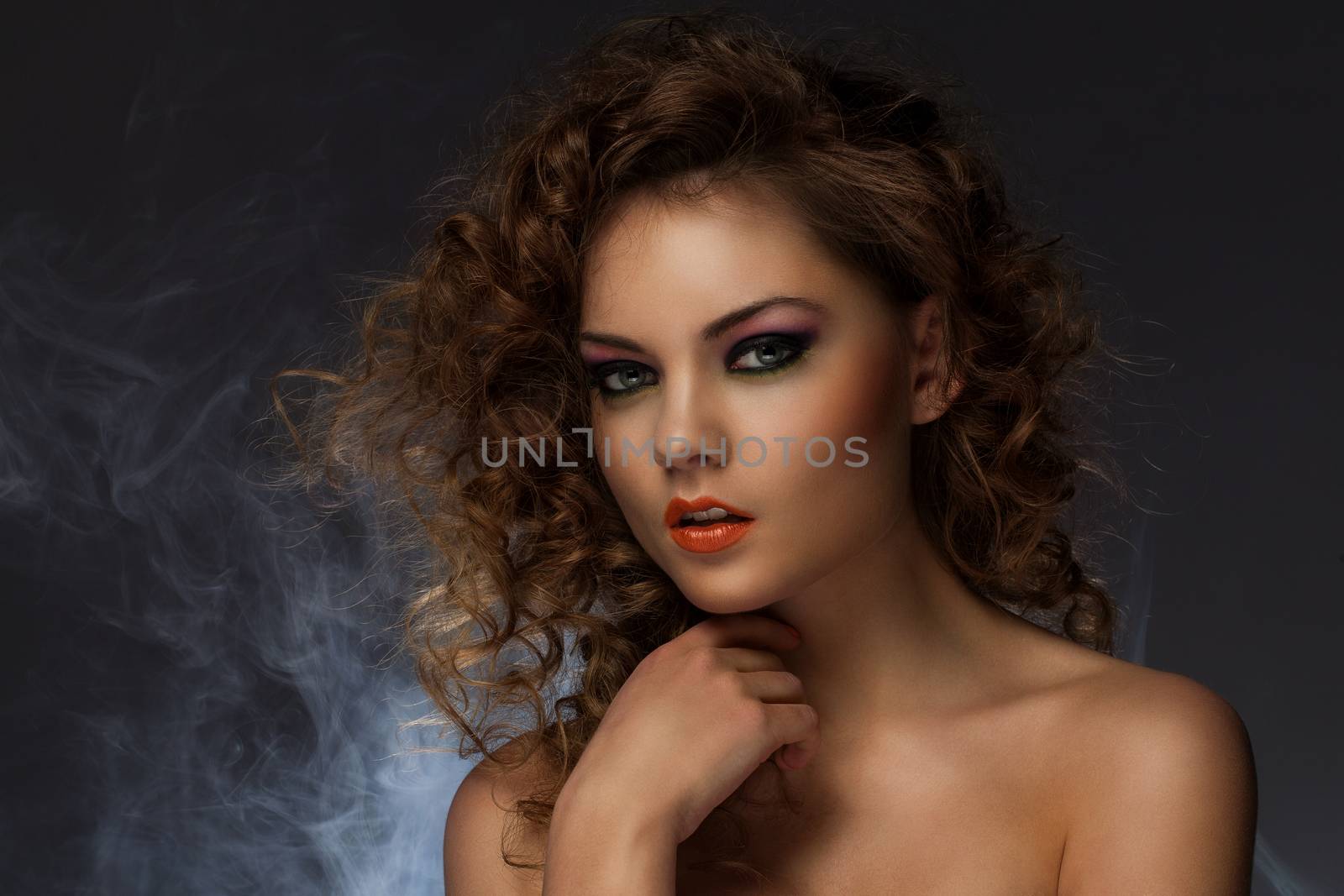 Beautiful caucasian woman with curls and evening makeup