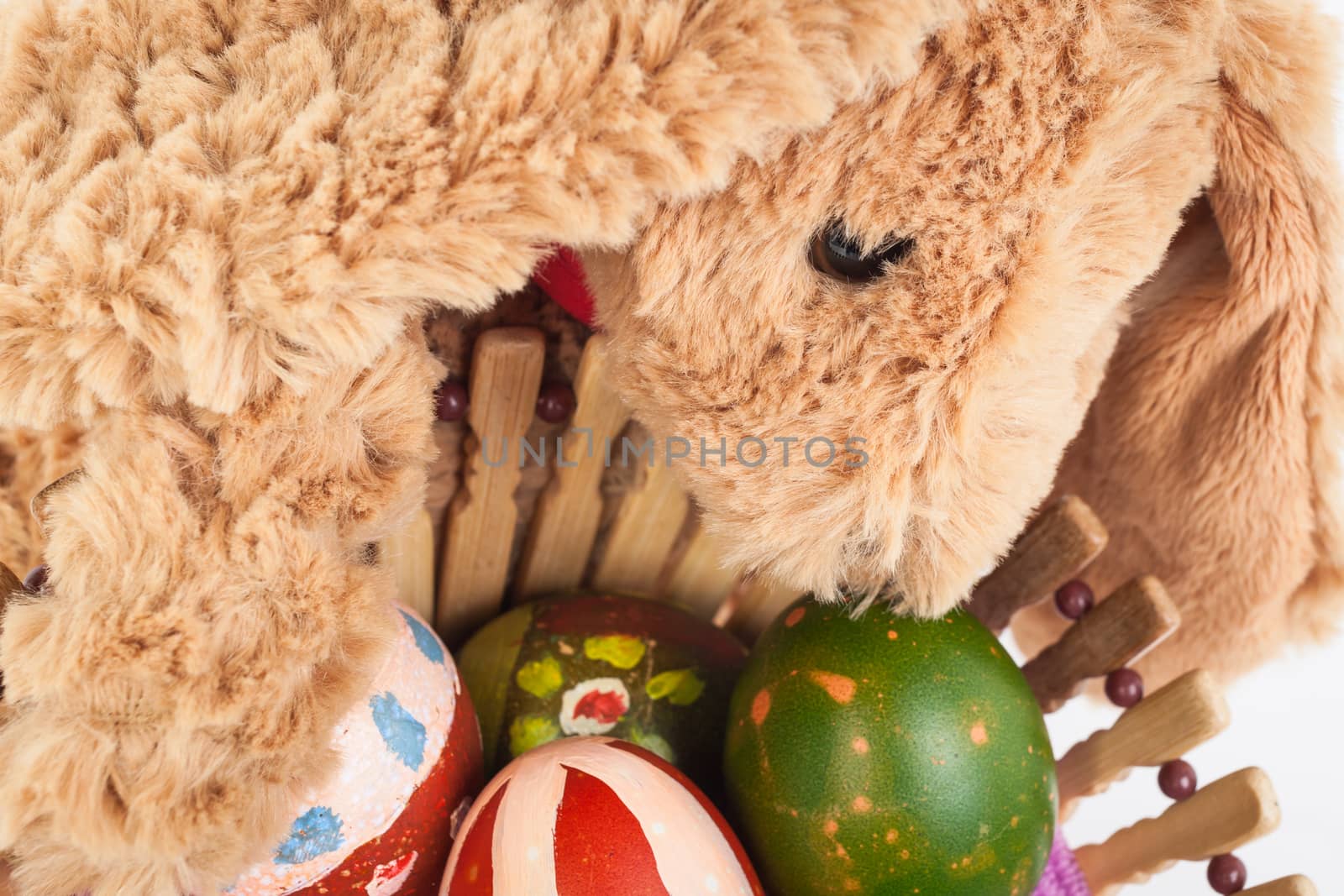 Rabbit, holding and take care colorful easter eggs in basket for happy festival