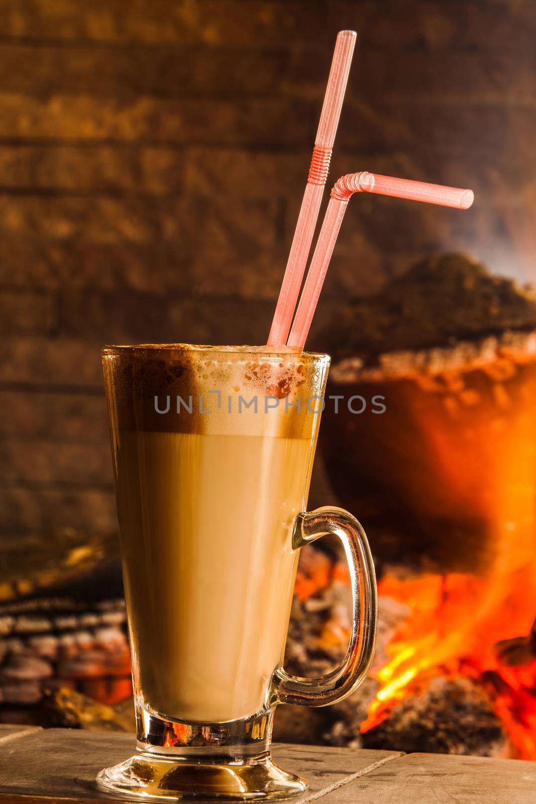 Glass of coffee cup  on the background of a burning fireplace