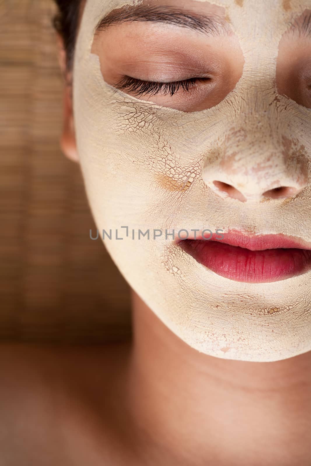 Close up of beautiful indian woman with closed eyes and having face mask of calamine