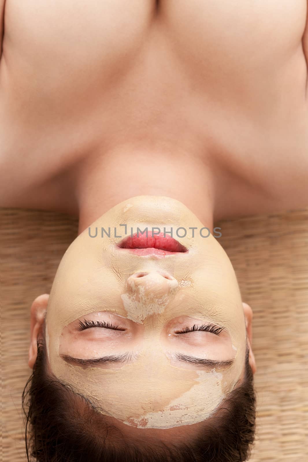 Beautiful indian woman with closed eyes and having face mask of calamine