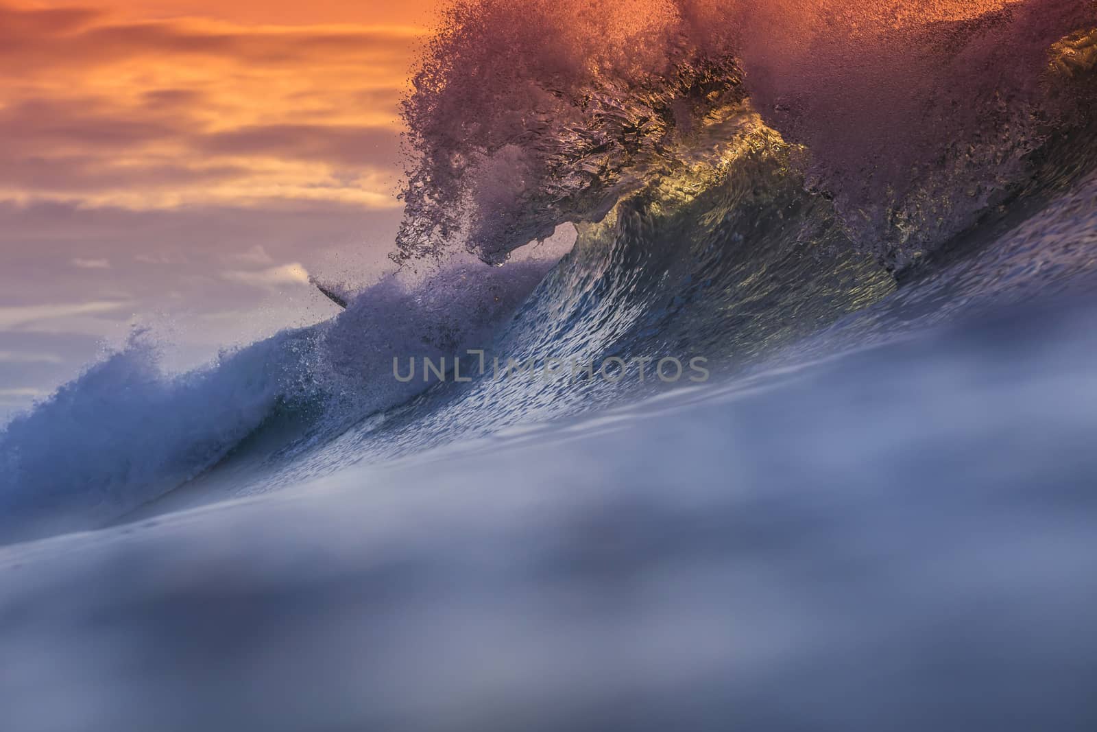 Colored Ocean Wave Falling Down at Sunset Time.