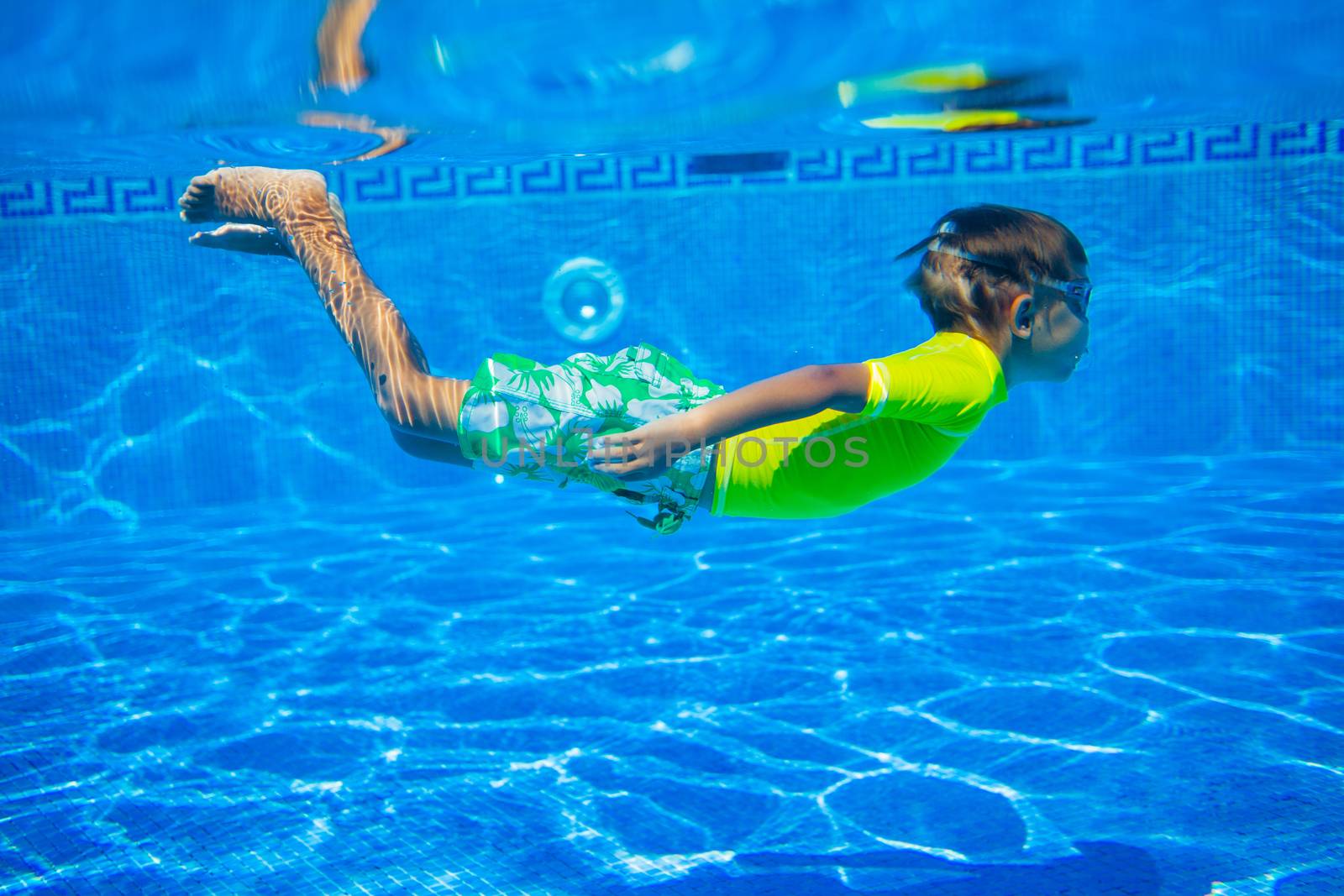 Underwater happy little boy in swimming pool