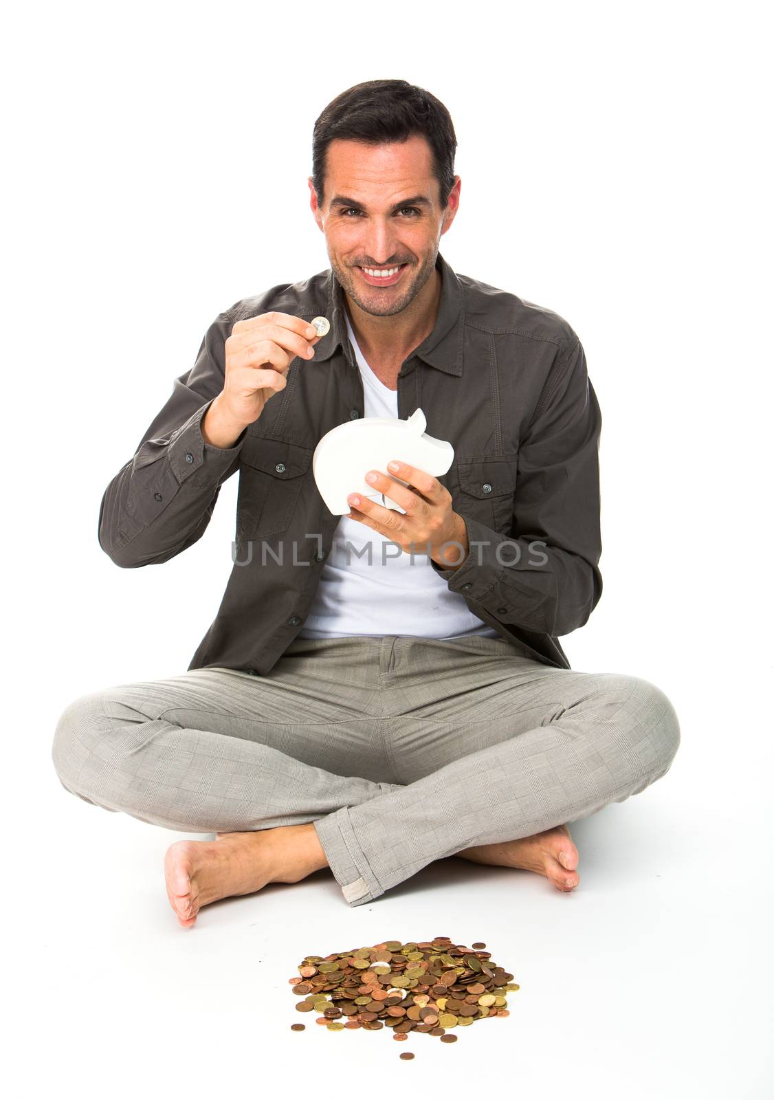 man seated on the floor with piggy bank by Flareimage