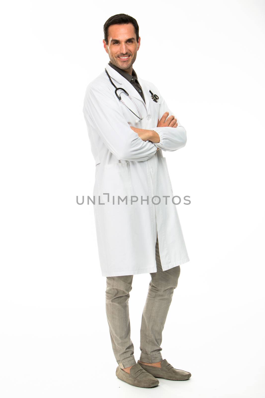 Full length portraif of a male doctor, smiling at camera with crossed arms and stethoscope