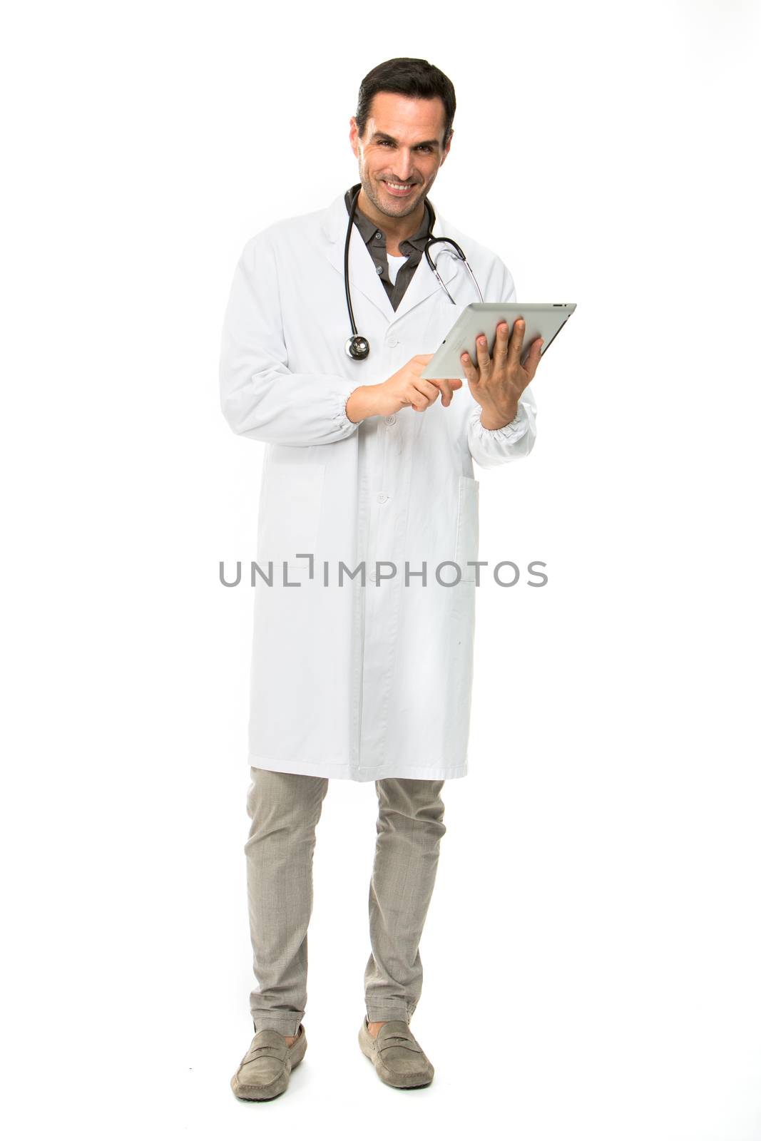 Full length portrait os a smiling male doctor with stethoscope while working with a dital tablet
