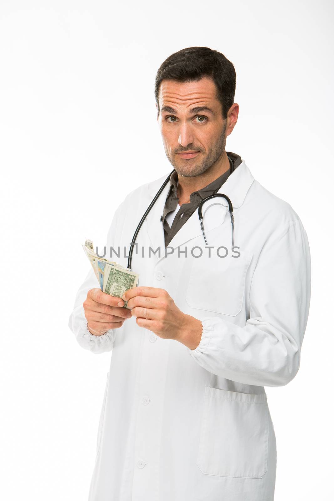 Half length portrait of a male doctor with stethoscope while counting money