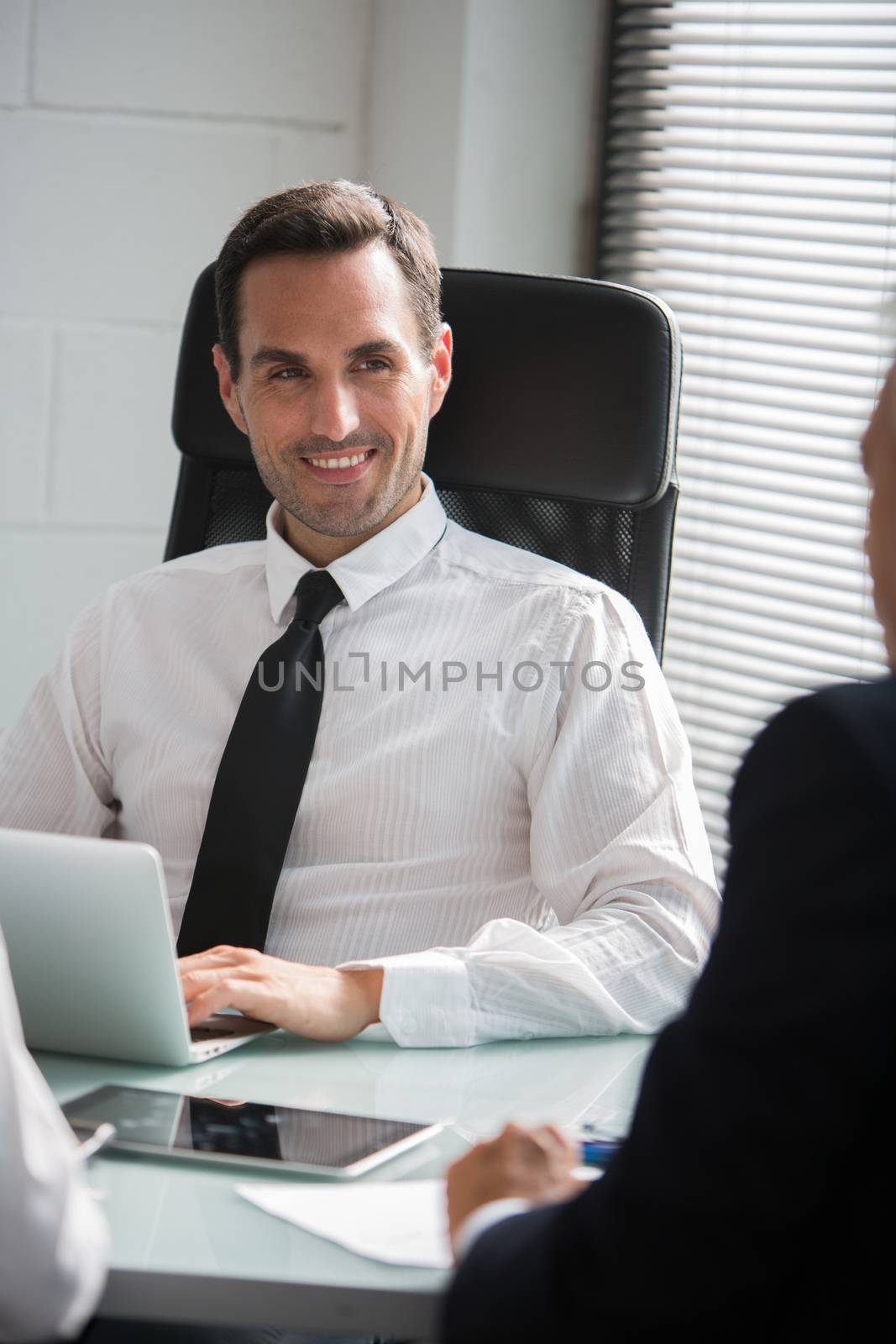 Three businesspeople having a meeting in the office with a laptop computer and a digital tablet