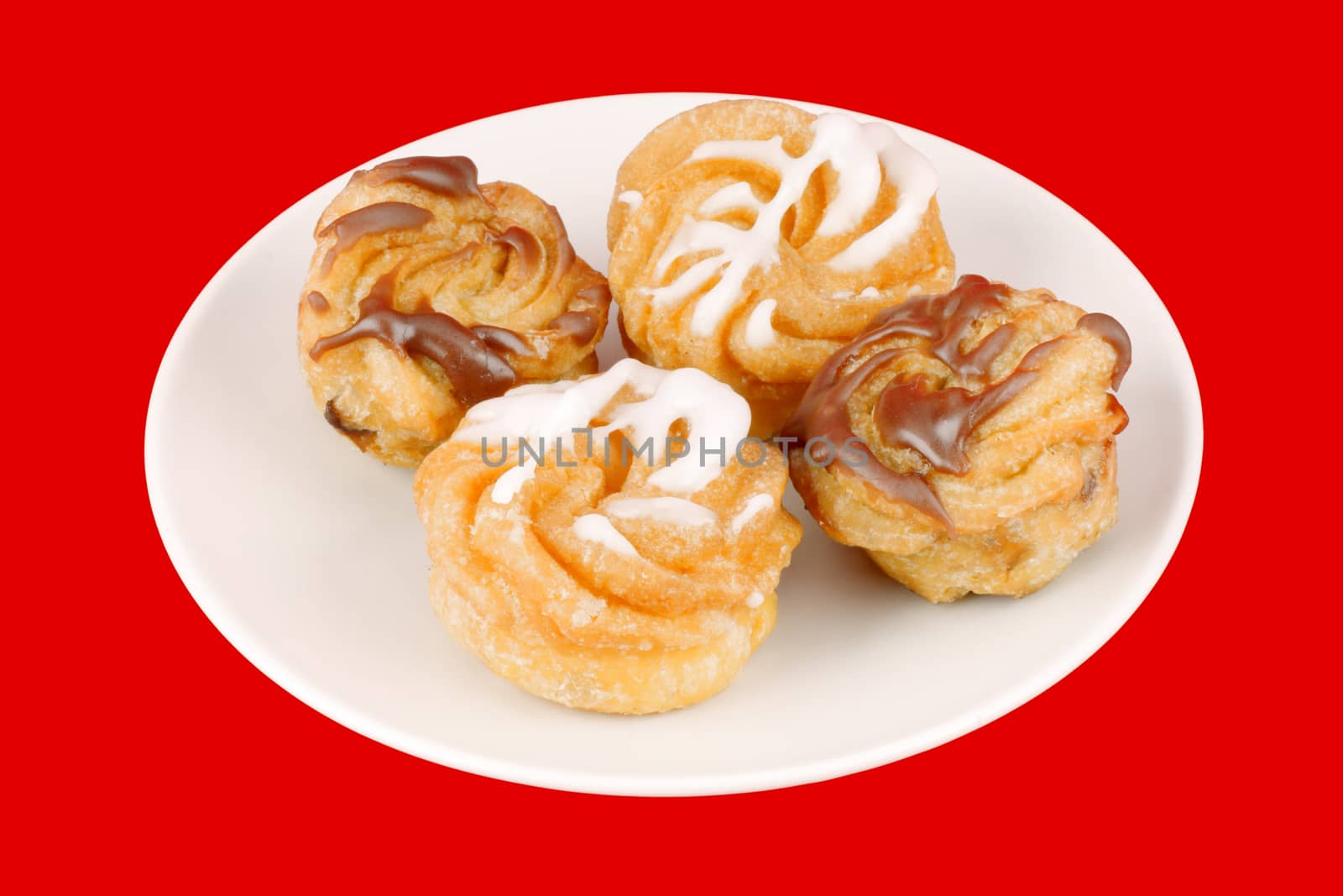 Zeppole di San Giuseppe or St. Joseph's Day Cream Puffs, are south italian deep fried cakes, filled with custard and frosted. Isolated on red.