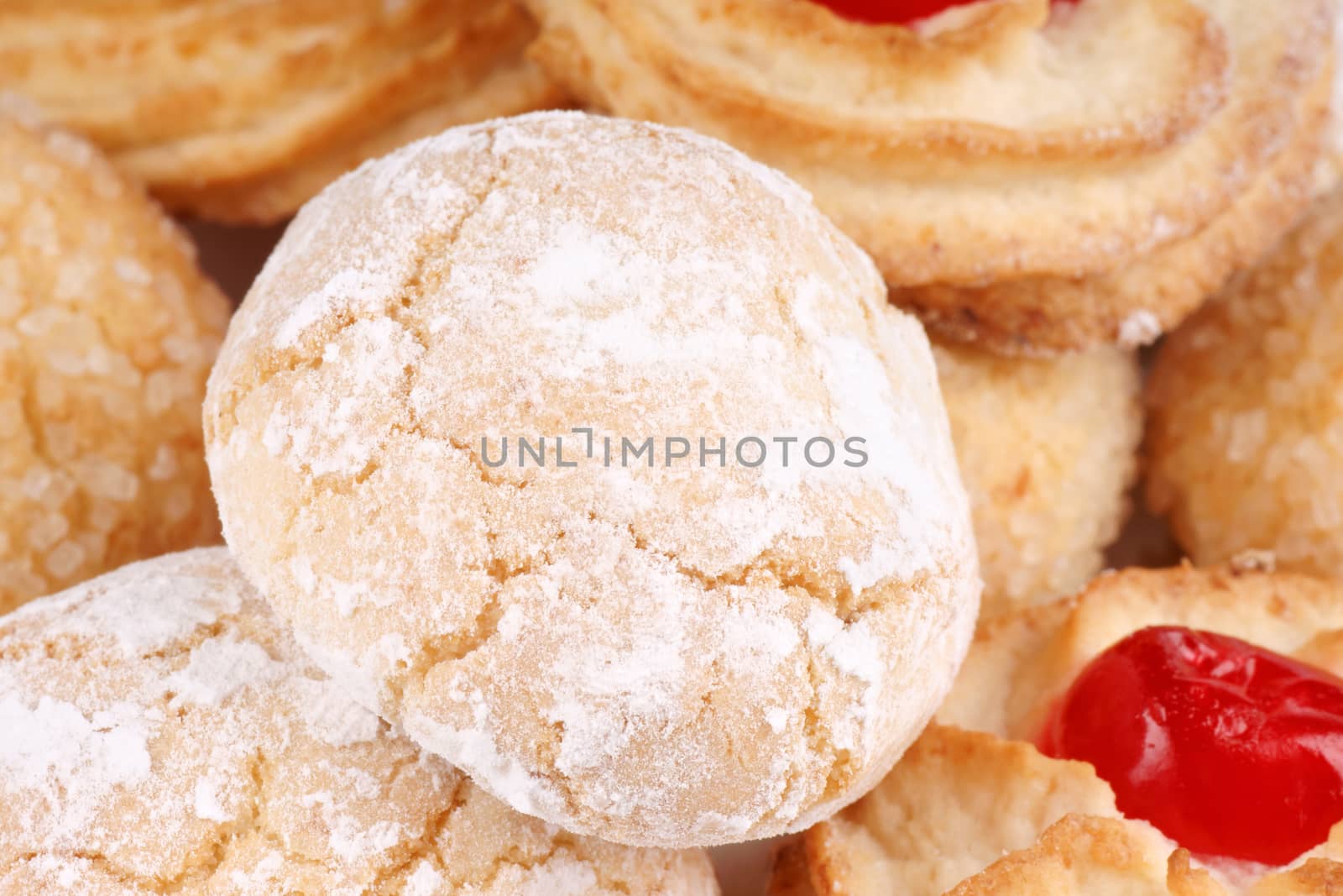 Close-up of assorted sicilian almond pastries decorated with candied cherries, icing sugar and granulated sugar. Selective focus.