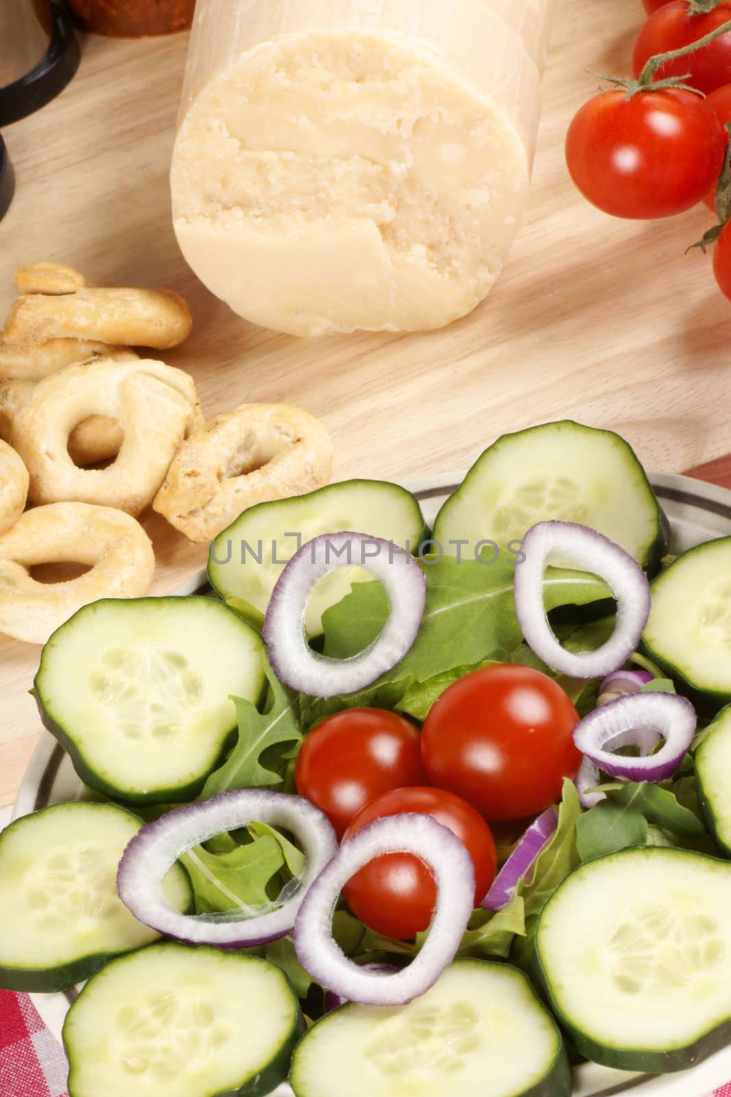 Close-up of a prepared table with an healthy salad, parmesan cheese and taralli. Selective focus.